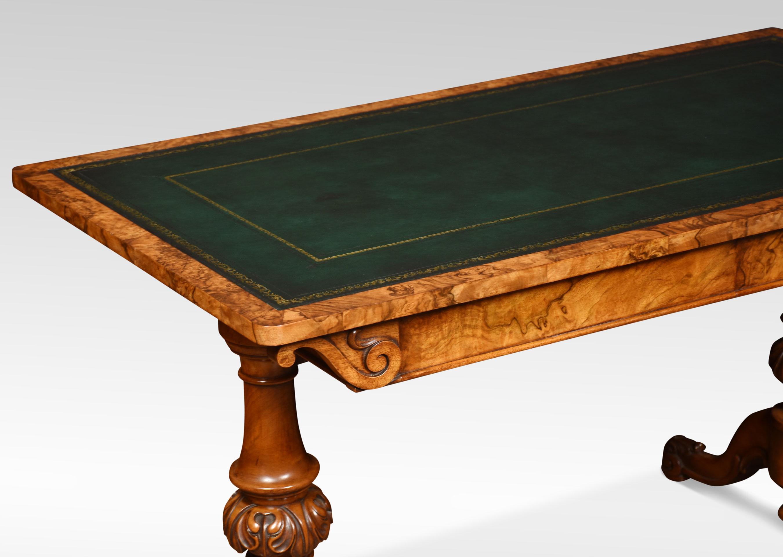 19th century walnut library table, the large rectangular top with rounded corners having tooled inset leather writing surface. The frieze is fitted with two freeze drawers supported on twin carved uprights. All raised up on cabriole legs terminating