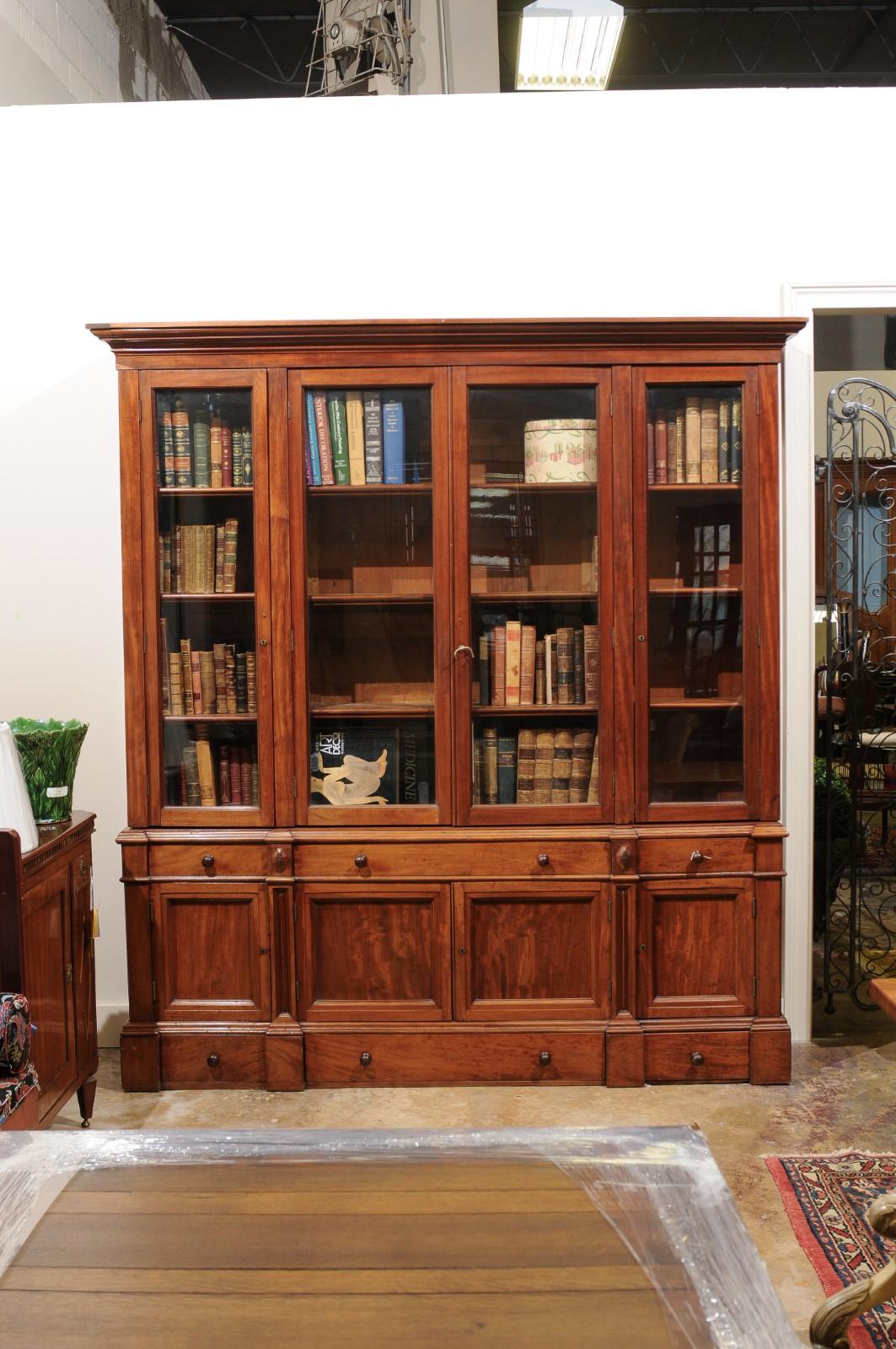 A Fine solid walnut bookcase with 4 glass doors that open to shelving
Below are 3 drawers (2 small on either side of 1 long}.
This sits on a cabinet with 4 raised panel doors. Above and below the doors are
2 short drawers on either side of a
