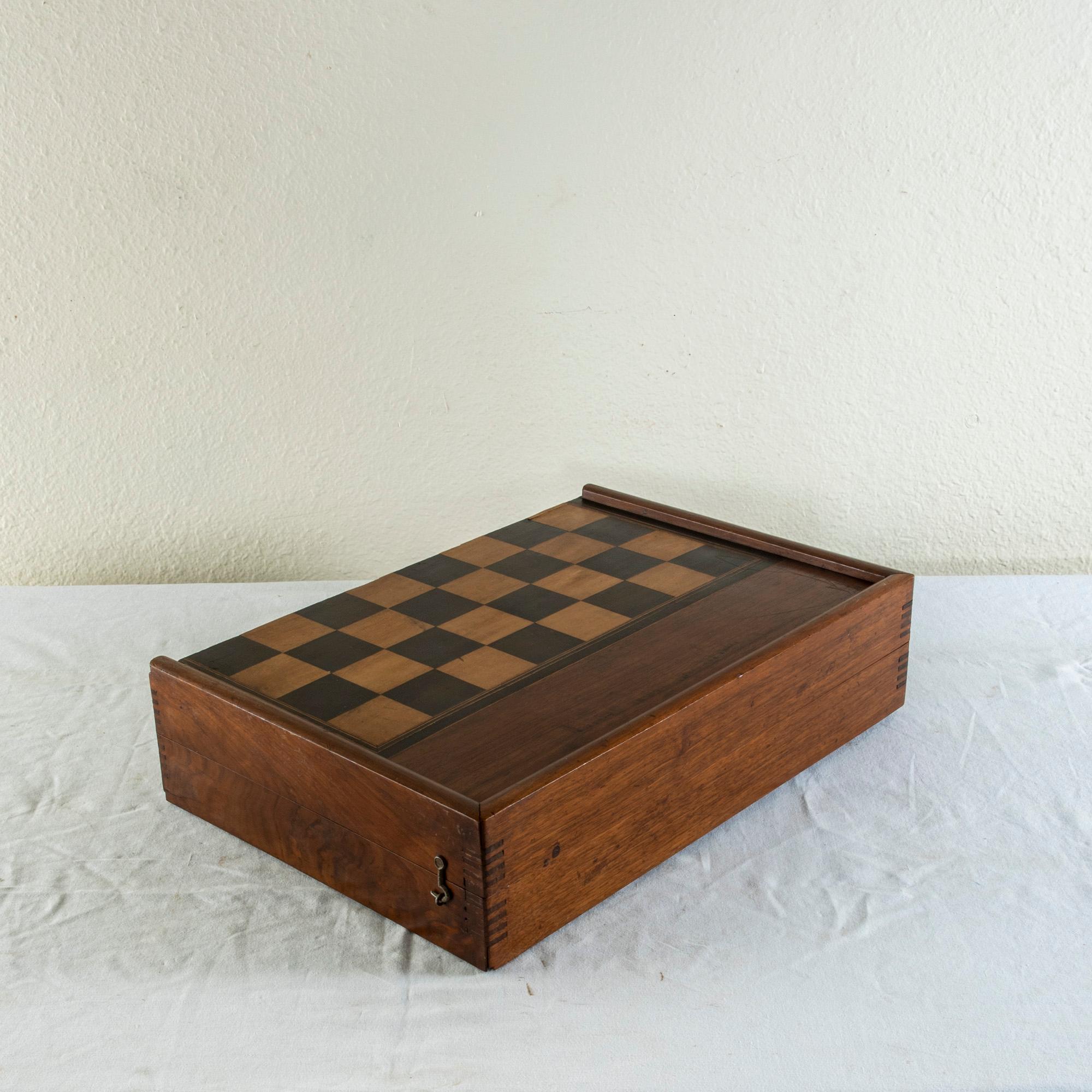 This French walnut marquetry folding game box from the mid-nineteenth century is for checkers, chess, and backgammon. It is finely constructed with dovetailed corners, inset hinges, and a locking brass hook on each side. The checker board side of