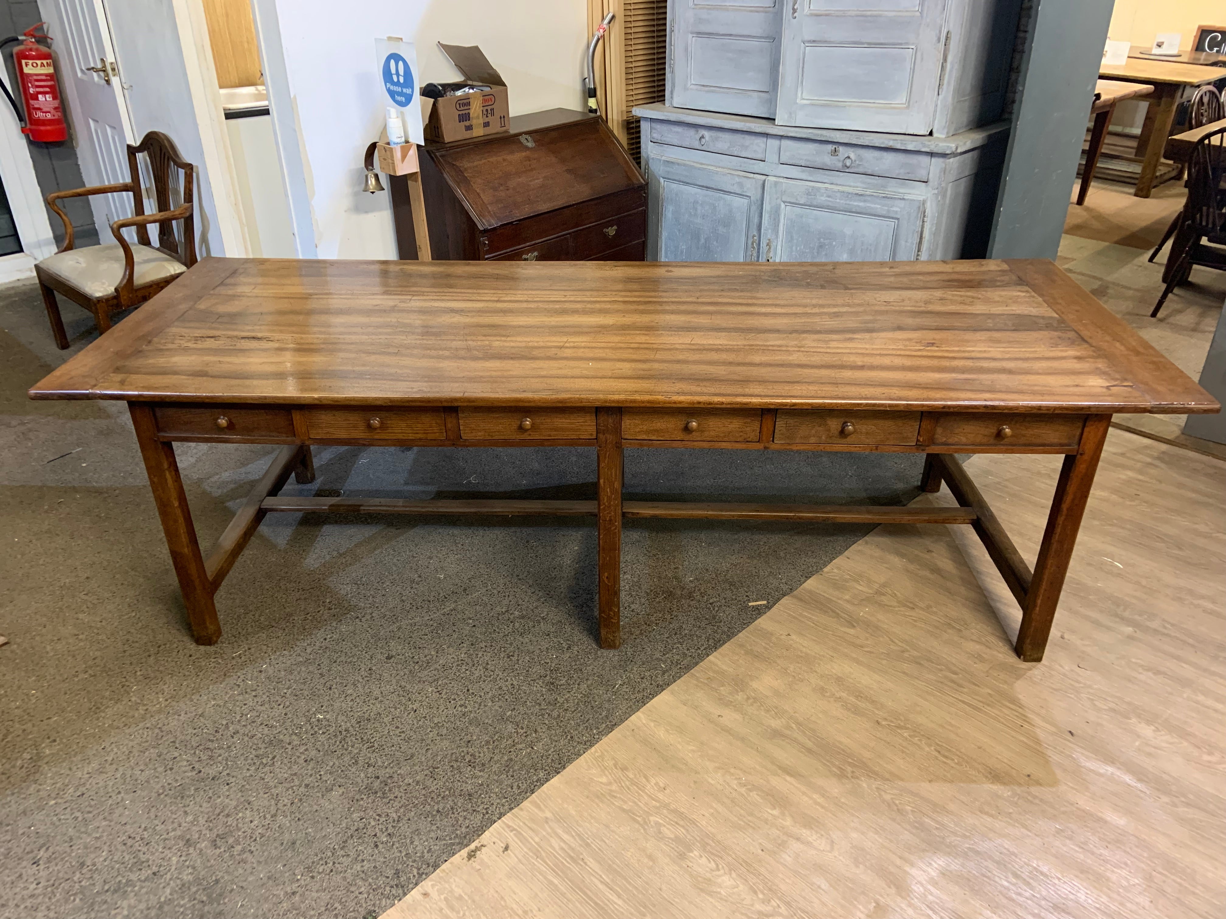 19th century walnut Monastery table with twelve drawers. The table sits on a sturdy oak base and has twelve lovely drawers. The drawers are all zinc lined and have wooden knobs. The base is joined by six legs and a centre stretcher. The top is a