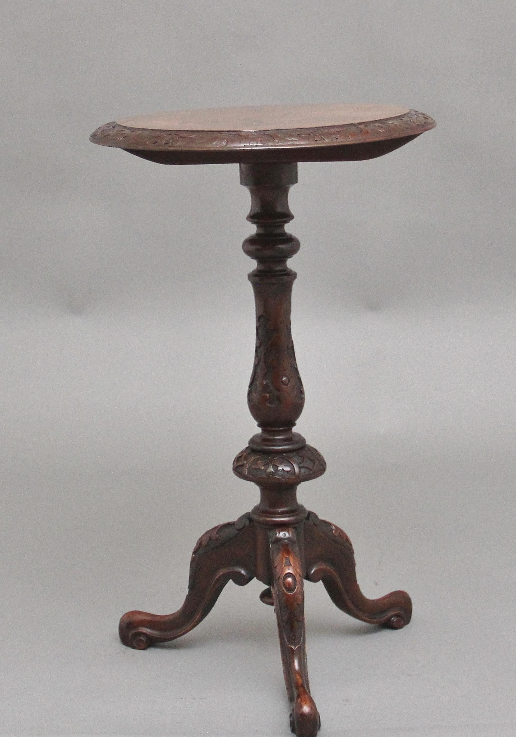 19th Century walnut wine / occasional table, having a wonderful figured oval top with a decorative floral carved edge raised on an intricate carved column with a turned finial at the bottom, supported on three carved cabriole legs terminating on