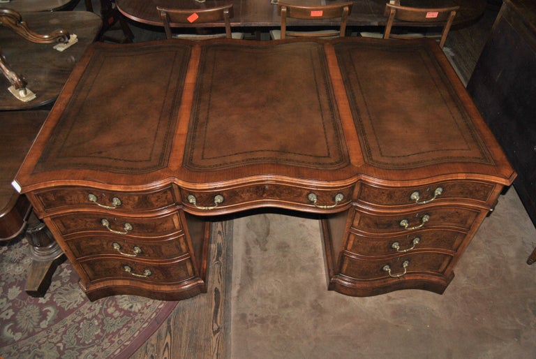 This is a walnut and Kashmir walnut partners desk made in England, circa 1890. The top of the desk is Walnut with 3 shaped pieces of beautiful brown leather with gold embossed tooling. The entirety of the desk below the top surface is done in a