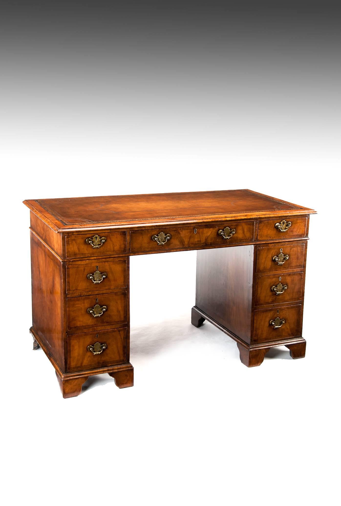 A very good quality figured walnut pedestal desk having a tan gilt tooled inset leather writing surface, circa 1880.
This extremely well-constructed pedestal desk has been made in the Queen Anne – George I style. Being an earlier model than the