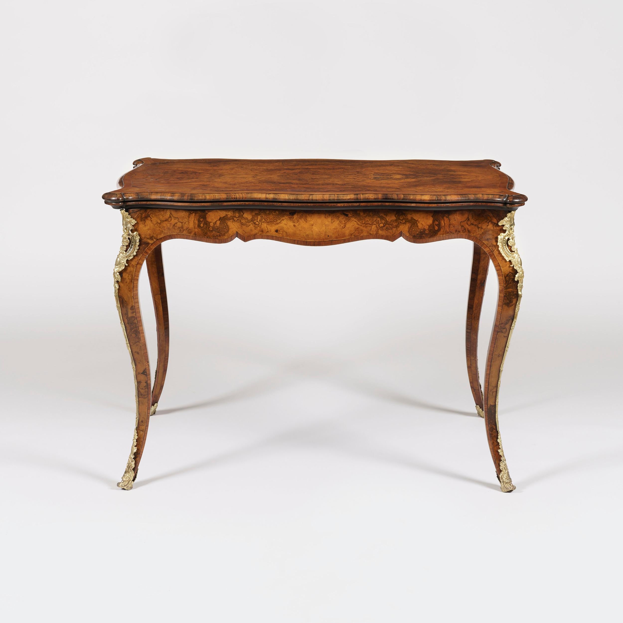 A walnut serpentine card table firmly attributed to Gillows
Constructed using finely figured Circassian walnut, dressed with gilt bronze mounts; rising from slender kingwood banded cabriole legs shod with bronze sabots and espagnolettes. The shaped