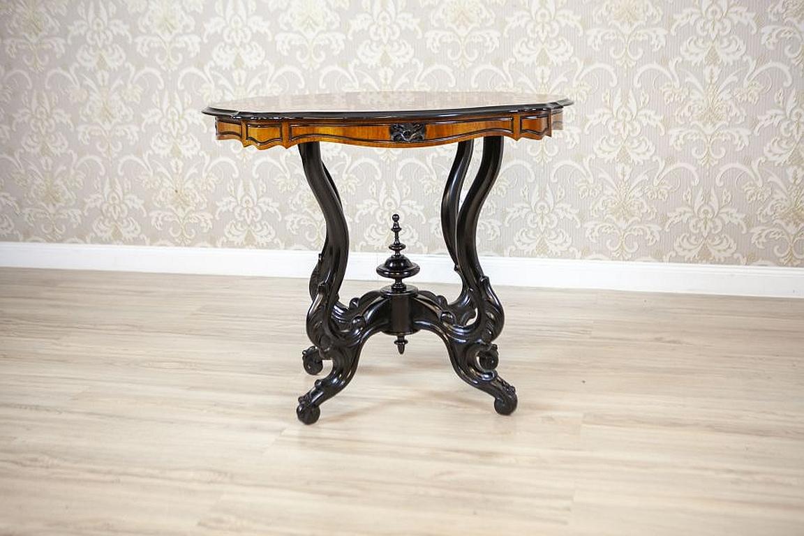 19th-Century Walnut Light Brown Side Table with Veneered Top

We present you this antique walnut side table from the late 19th century. The top is covered in walnut veneer with an elaborate pattern. The oval top is of a wavy shape. The base composed