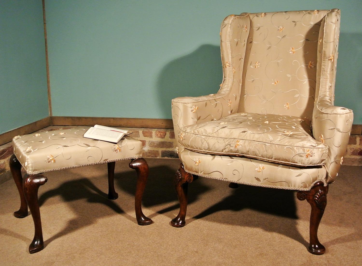 A very beautiful walnut wing armchair with out-scrolling arms, shapely winged back and long cabriole legs carved with scallop shells and drop bell husks.

Newly upholstered in a luxurious 100% silk heavyweight upholstery fabric of a soft gilt