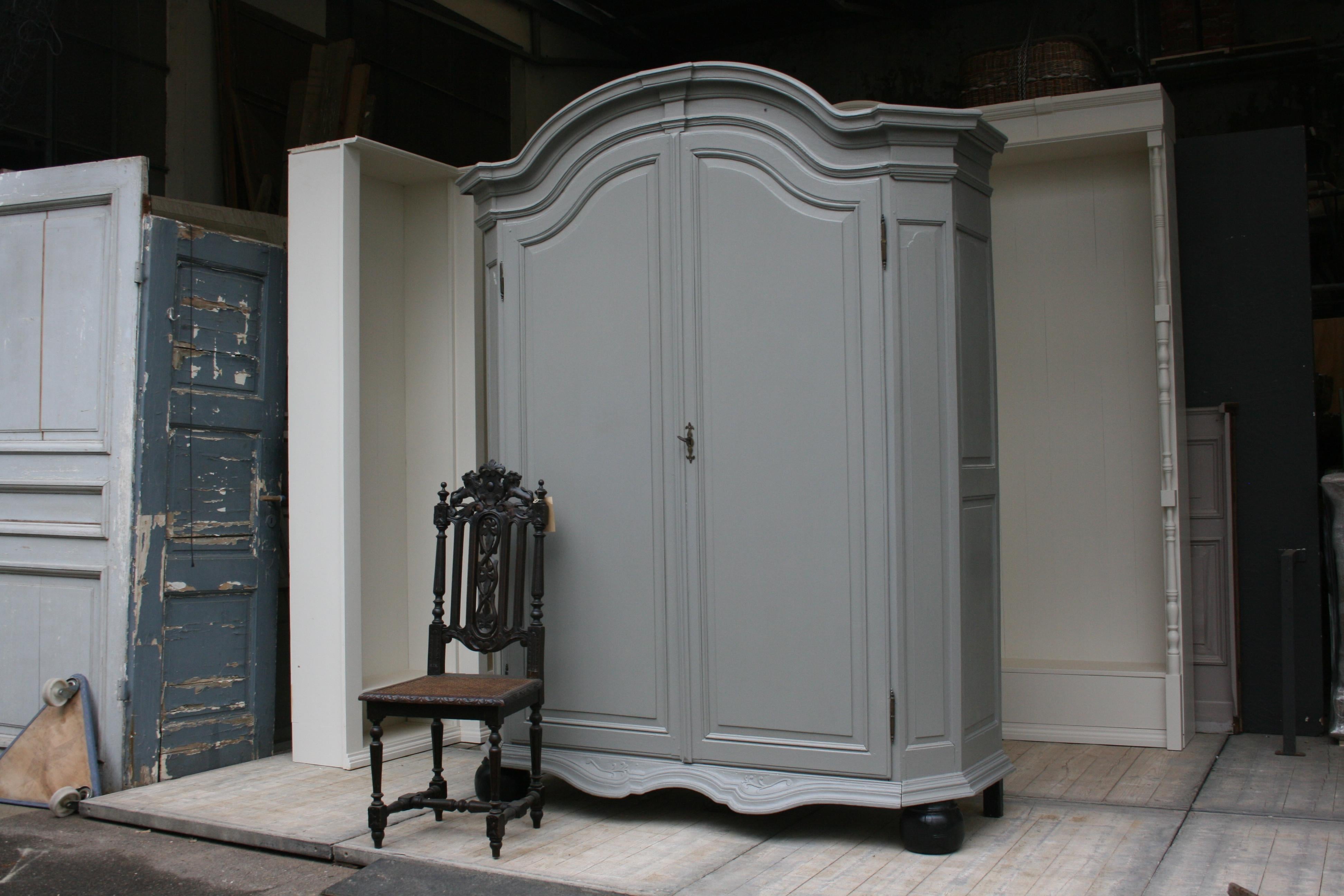 Impressive large wardrobe or cupboard from circa 1860 made of oak.
Refurbished and newly painted over with gray paint on the outside.
Standing on 2 large black painted ball feet and 3 simple stud feet with arched cornice and cranked corners. Two