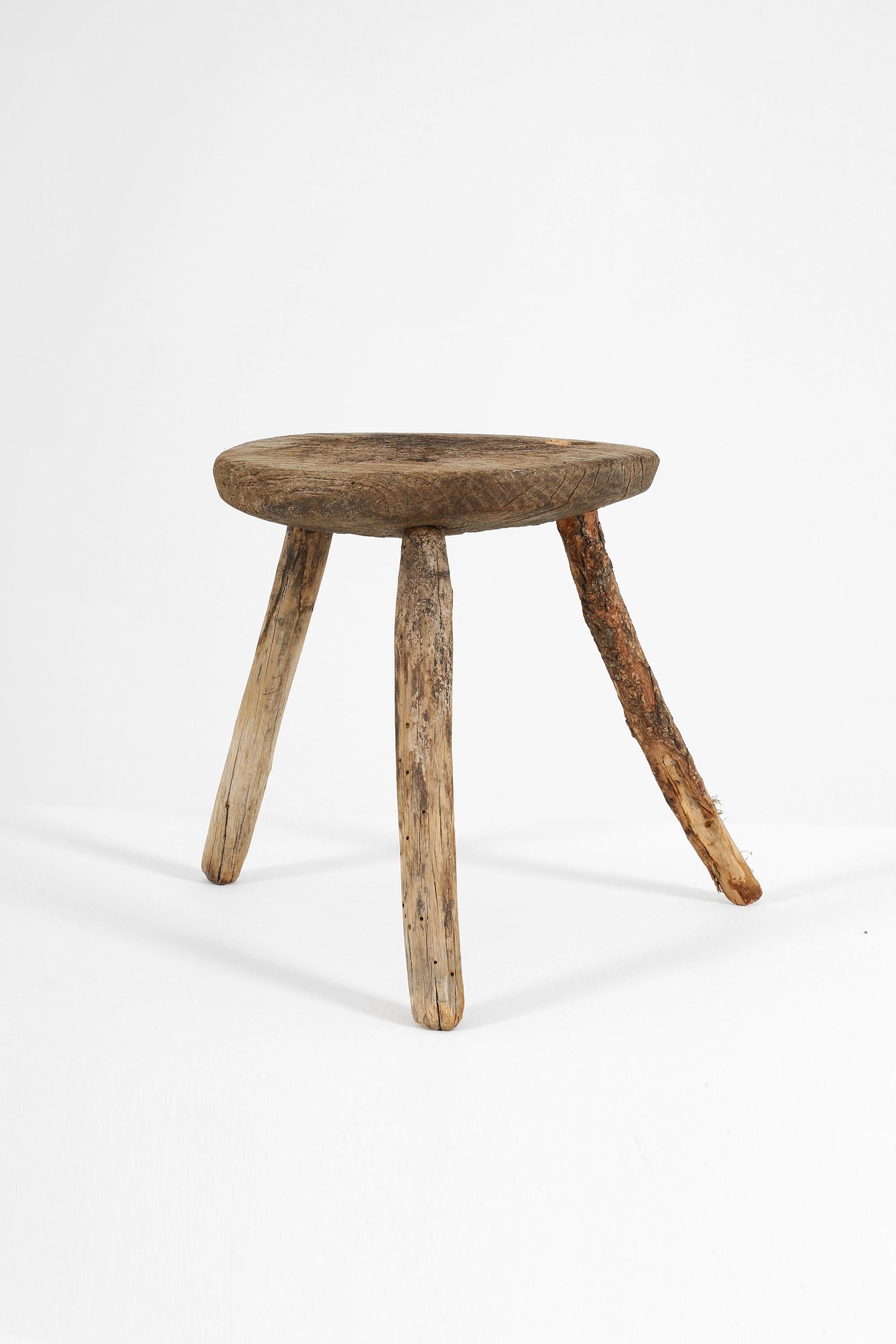 A small 19th century rustic weathered stool from the hilltop city of Matera. The scarred top suggesting a utilitarian past, with one leg a much later replacement. Italian, c. 1860.