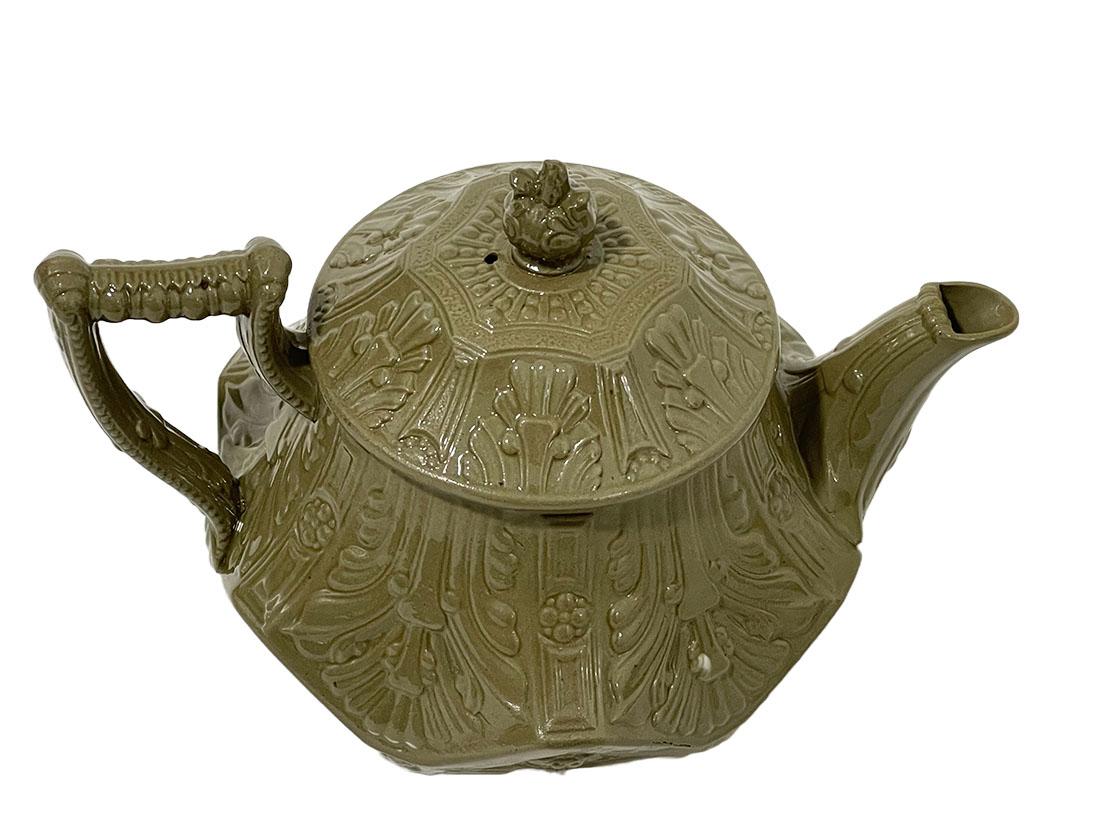 19th Century wedgwood Etruria drab stoneware smear-glazed teapot

A wedgwood teapot in Drab stoneware smearglazed green with raised relief, model 153. The teapot has a firing flaw and color difference (stain). Hoffstaedt collected order payments