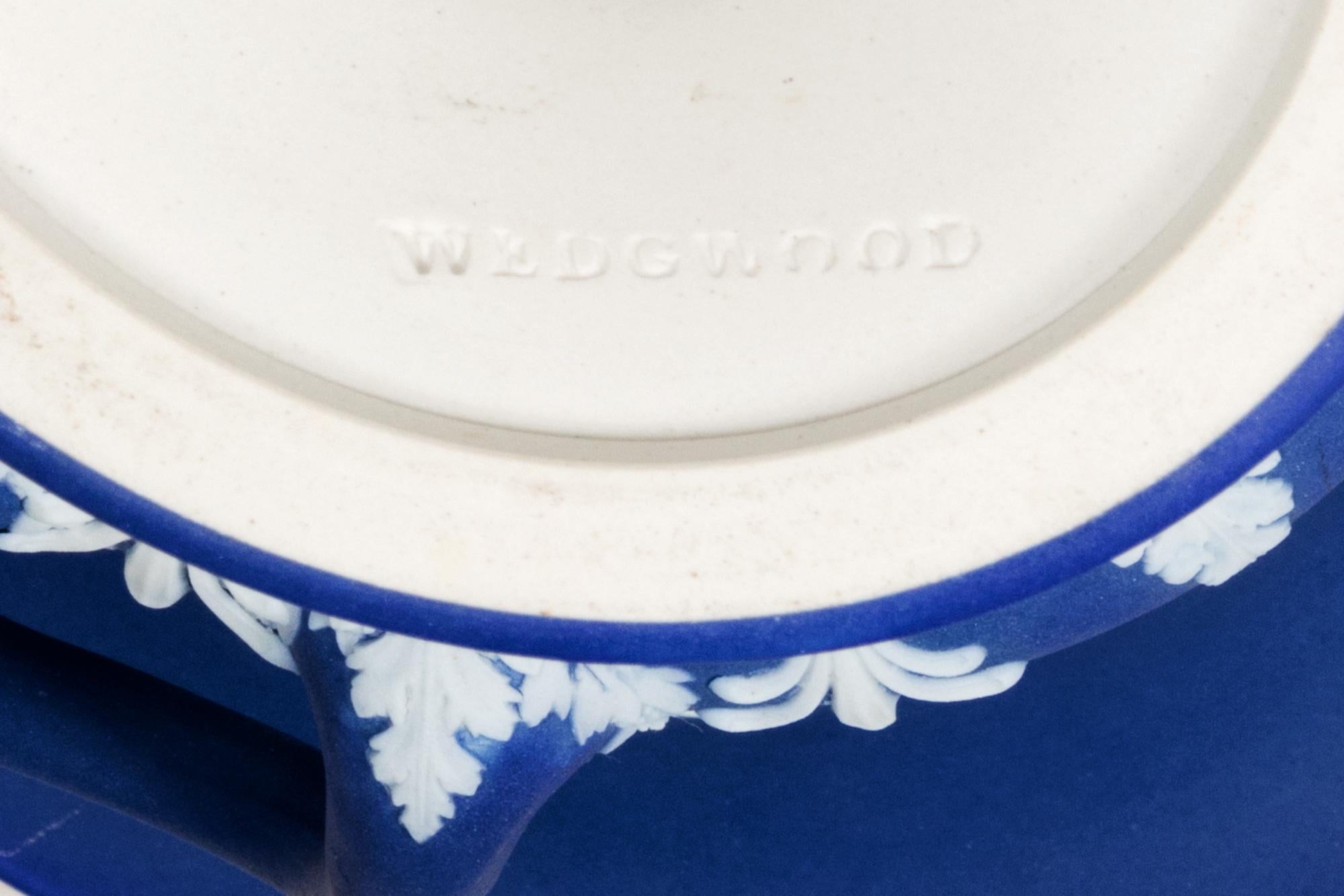 19th Century Wedgwood Jasperware twin handled campagne urn and cover, in the Neoclassical style, decorated with a frieze of Greek figures, with palmette borders in white on a blue background.