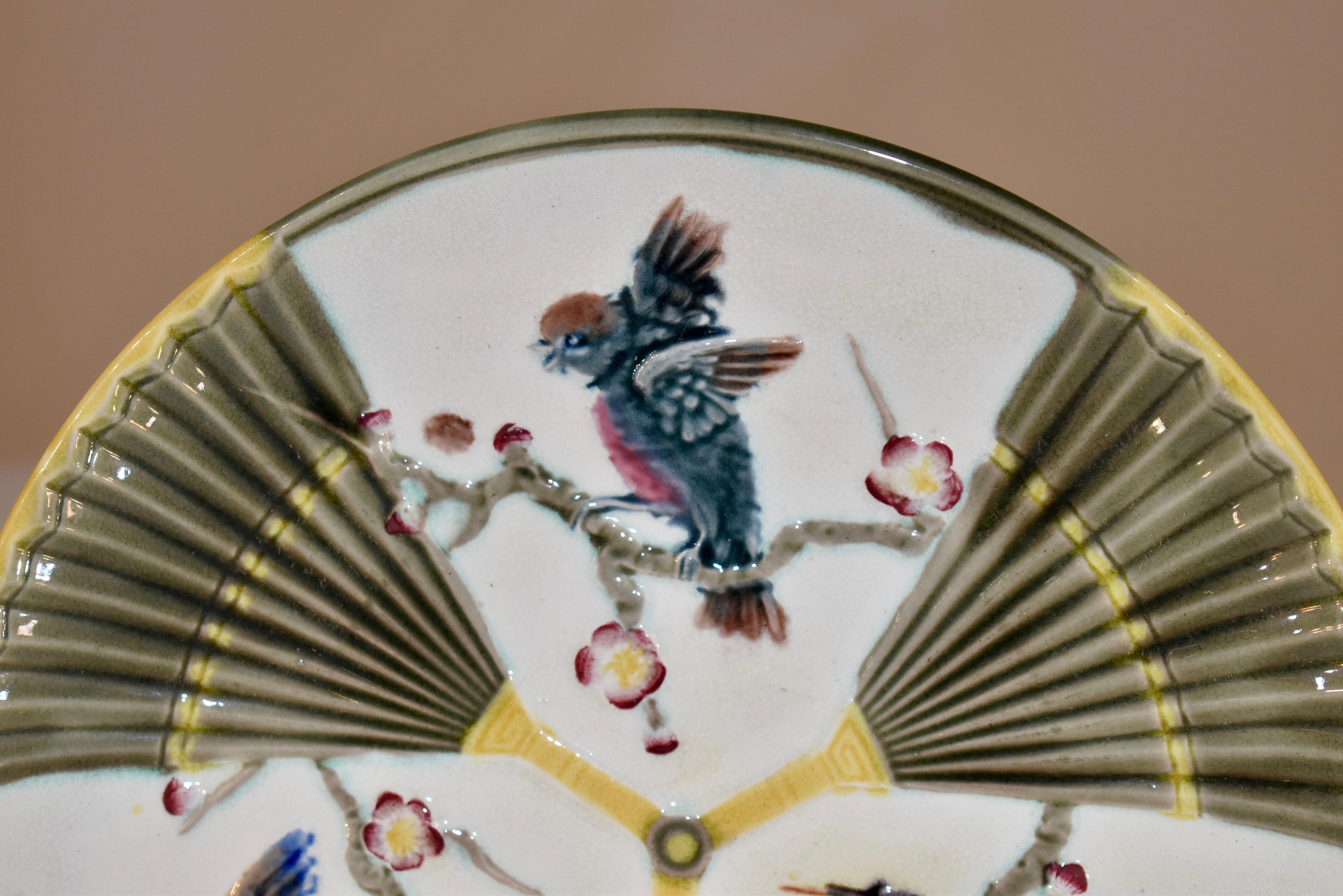 Assiette à motif d'oiseau et d'éventail en majolique du 19e siècle en Angleterre. La marque WEDGWOOD est imprimée au dos de l'assiette. Les couleurs sont vives et jolies.