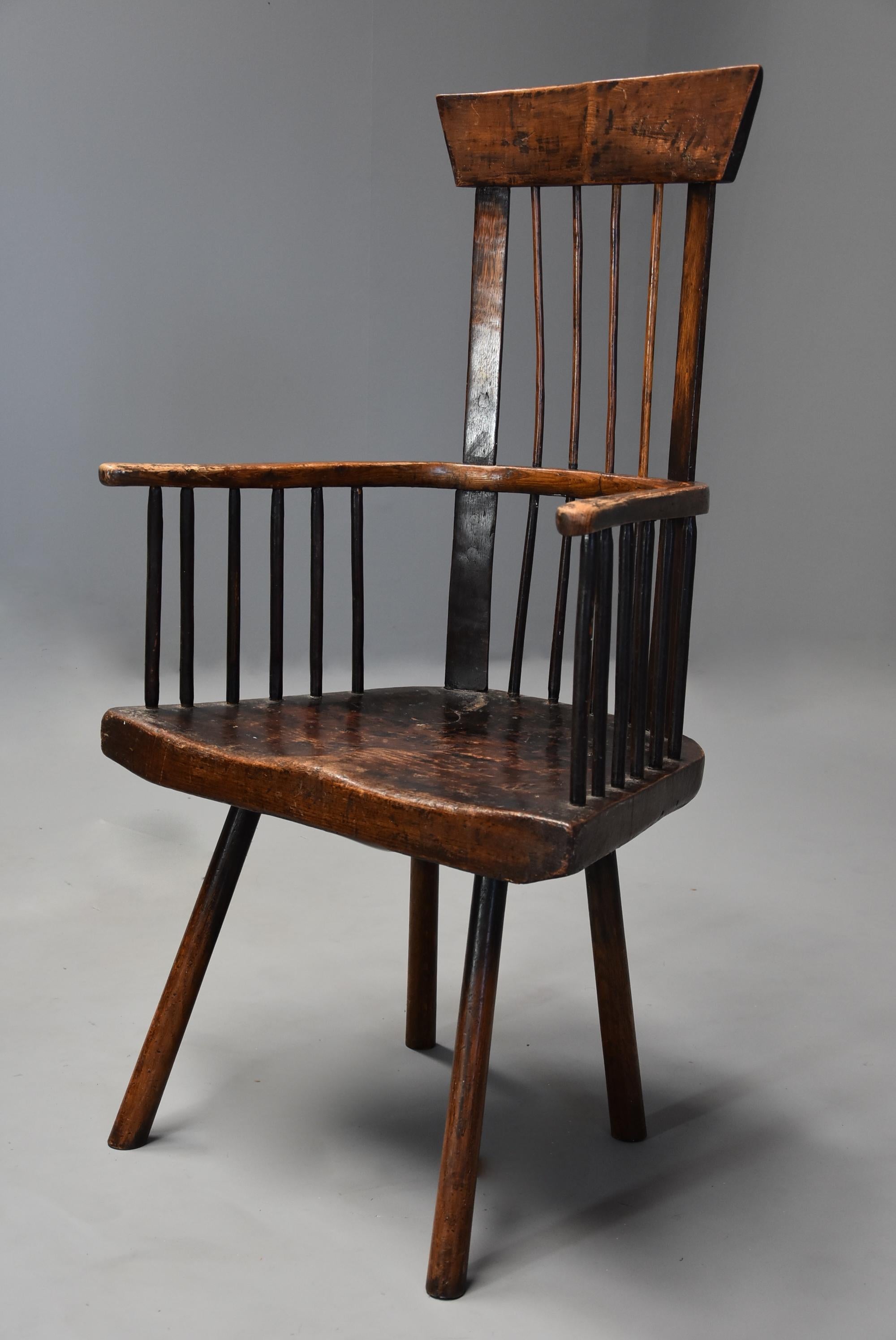 A mid 19th century Welsh primitive ash and elm comb back armchair with good patina (color).

This chairs consists of an ash comb back with four turned spindles with wider uprights, the arm bow supported by turned spindles leading down to the