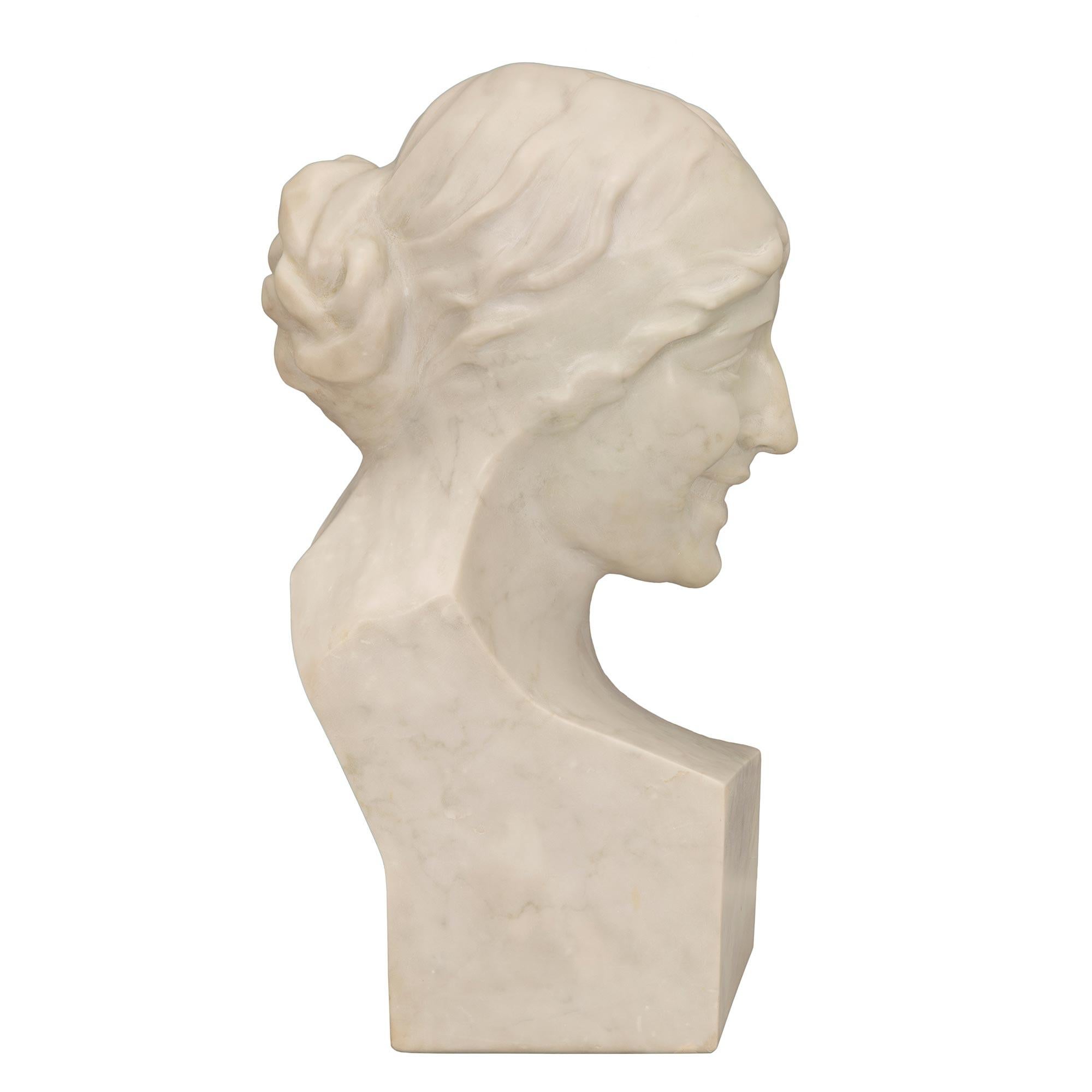A lovely 19th century white Carrara marble bust of a young maiden signed, L. Correa Morales 1875. The bust is raised by a square base where the signature is displayed at the back. The beautiful and richly sculpted young woman wears her hair tied