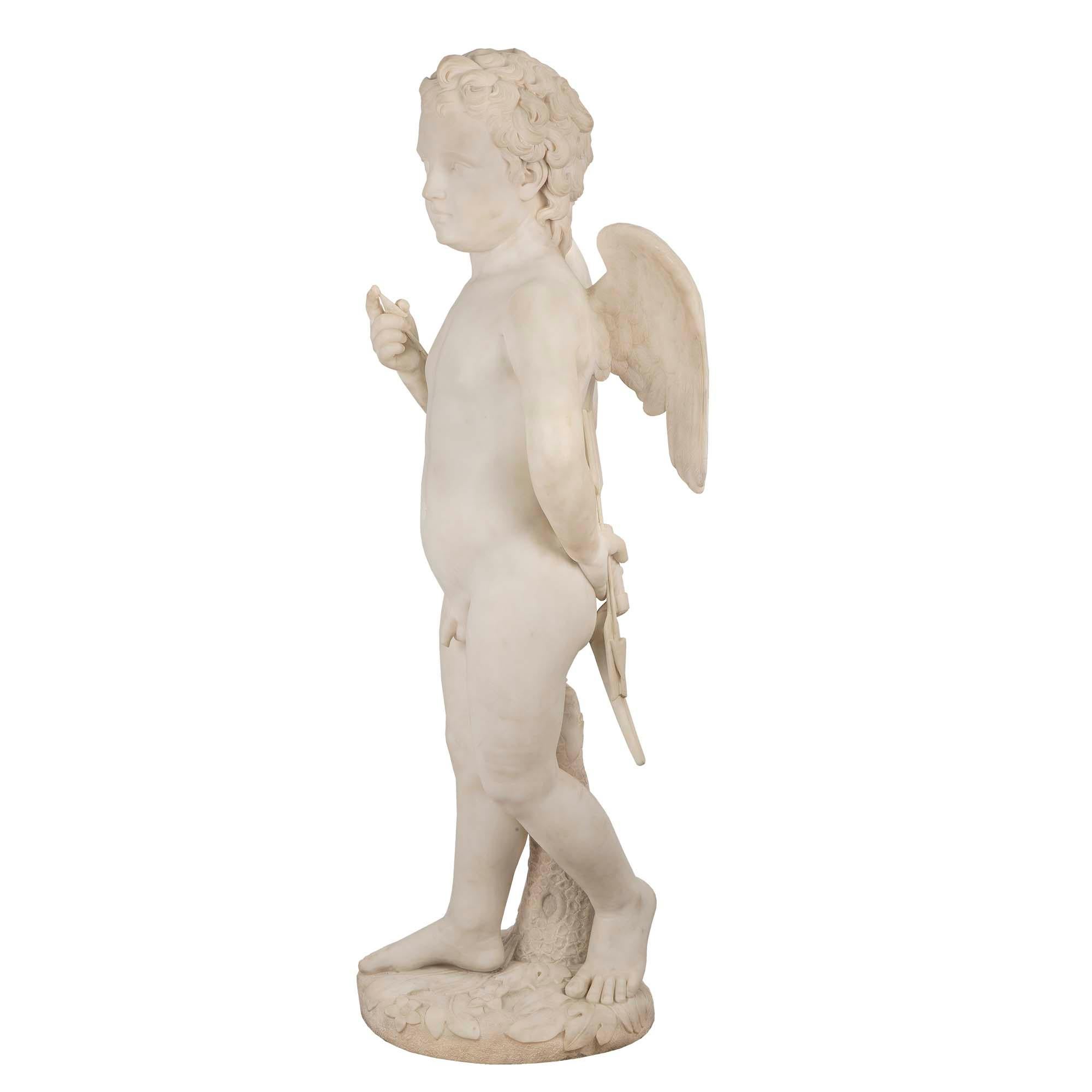 An American mid 19th century solid white Carrara sculpture of a winged cupid, signed Chauncey Bradley Ives. Cupid is raised on a terrain designed circular base holding an arrow with his right hand. His left hand is behind his back grasping his bow