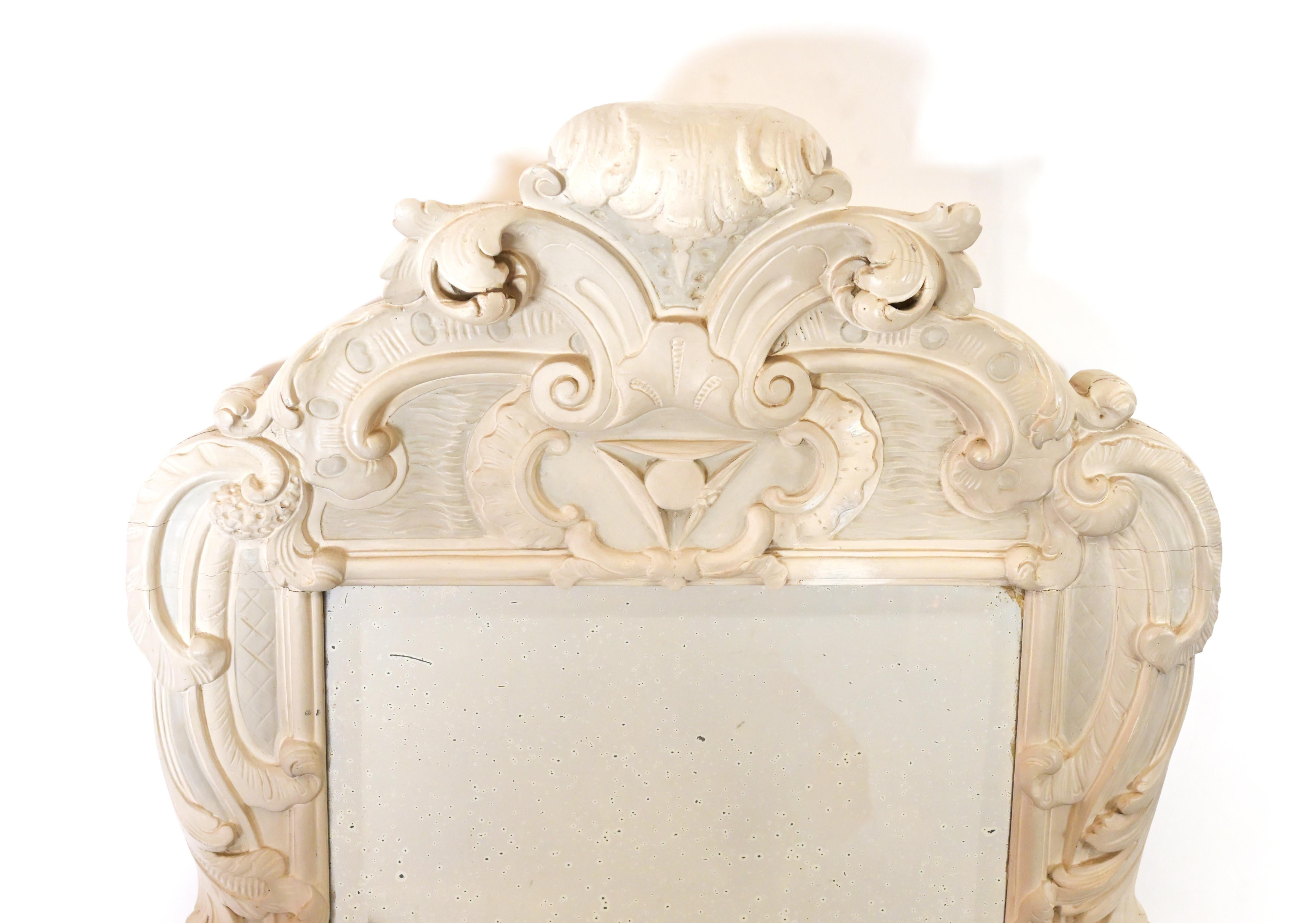 A 19th century Empire style mirror hand carved with intricate and ornately carved leaf and shell motifs, circa 1850.