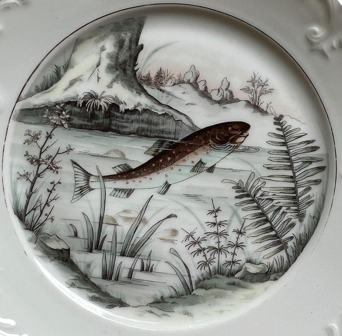 A beautiful white porcelain plate with scrolls and gilt trim. Plate has a hand painted fish in muted colors. One of my favorites, so delicate. No makers marks.
