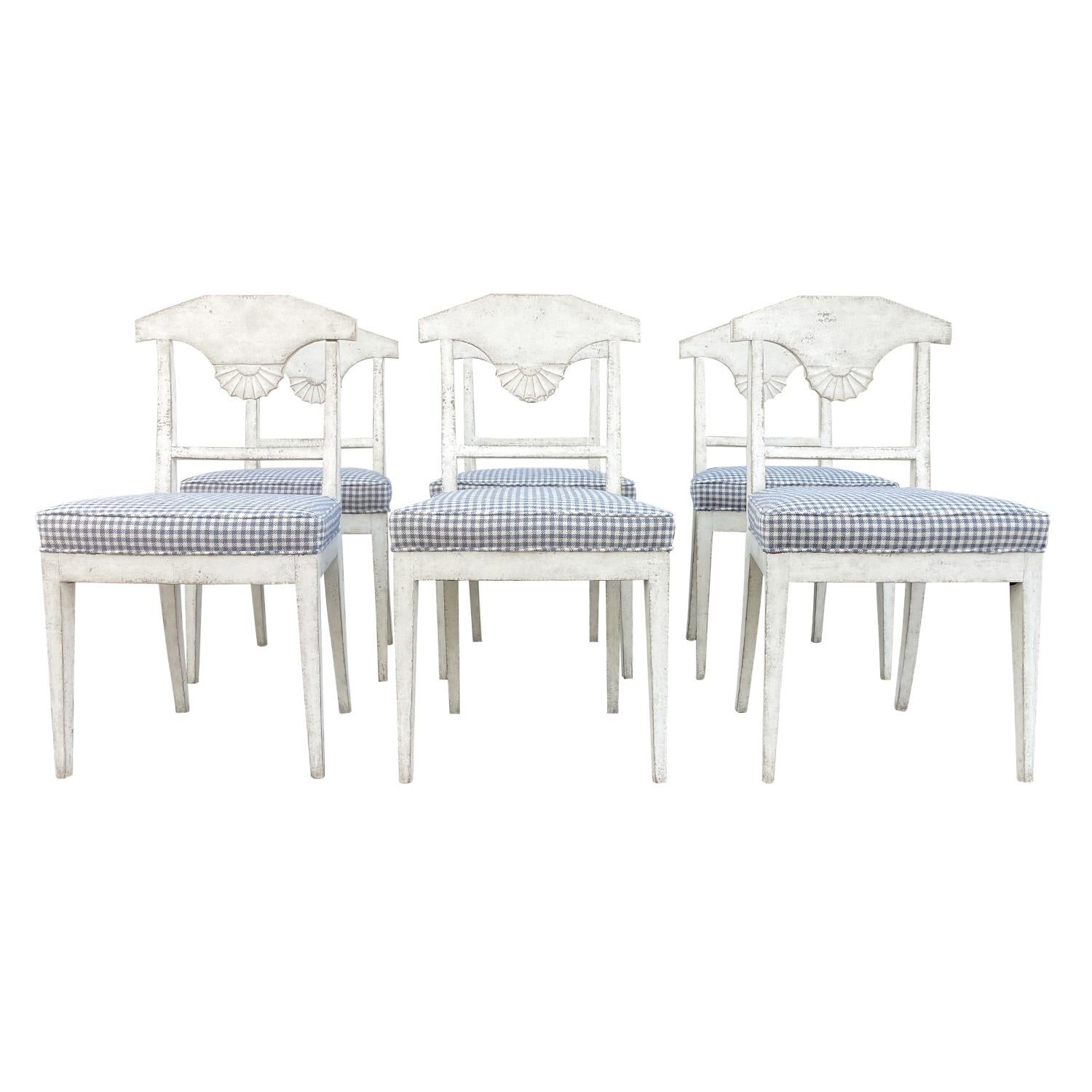 A white-grey, antique Danish Gustavian set of six dining room chairs made of hand crafted painted Pinewood, detailed in the Neoclassical Greek style, in good condition. The seat backrest of the Scandinavian side, corner chairs are enhanced by shell
