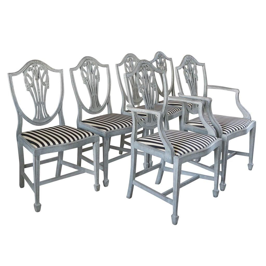 An antique Swedish Gustavian set of six dining chairs composed of two armchairs and four side chairs with very fine neoclassical carvings, made of hand carved pinewood, in good condition and upholstered in a striped fabric. Wear consistent with age