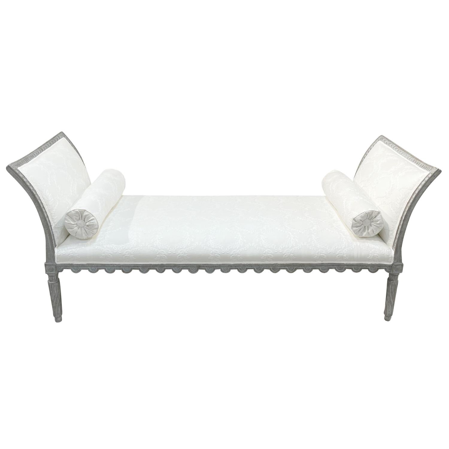 A white-grey, antique Swedish Gustavian daybed, wood sofa with two round pillows made of hand carved Pinewood, in good condition. The side rests of the freestanding Scandinavian Lit Du Jour are curved, outstretched, supported by four, small round