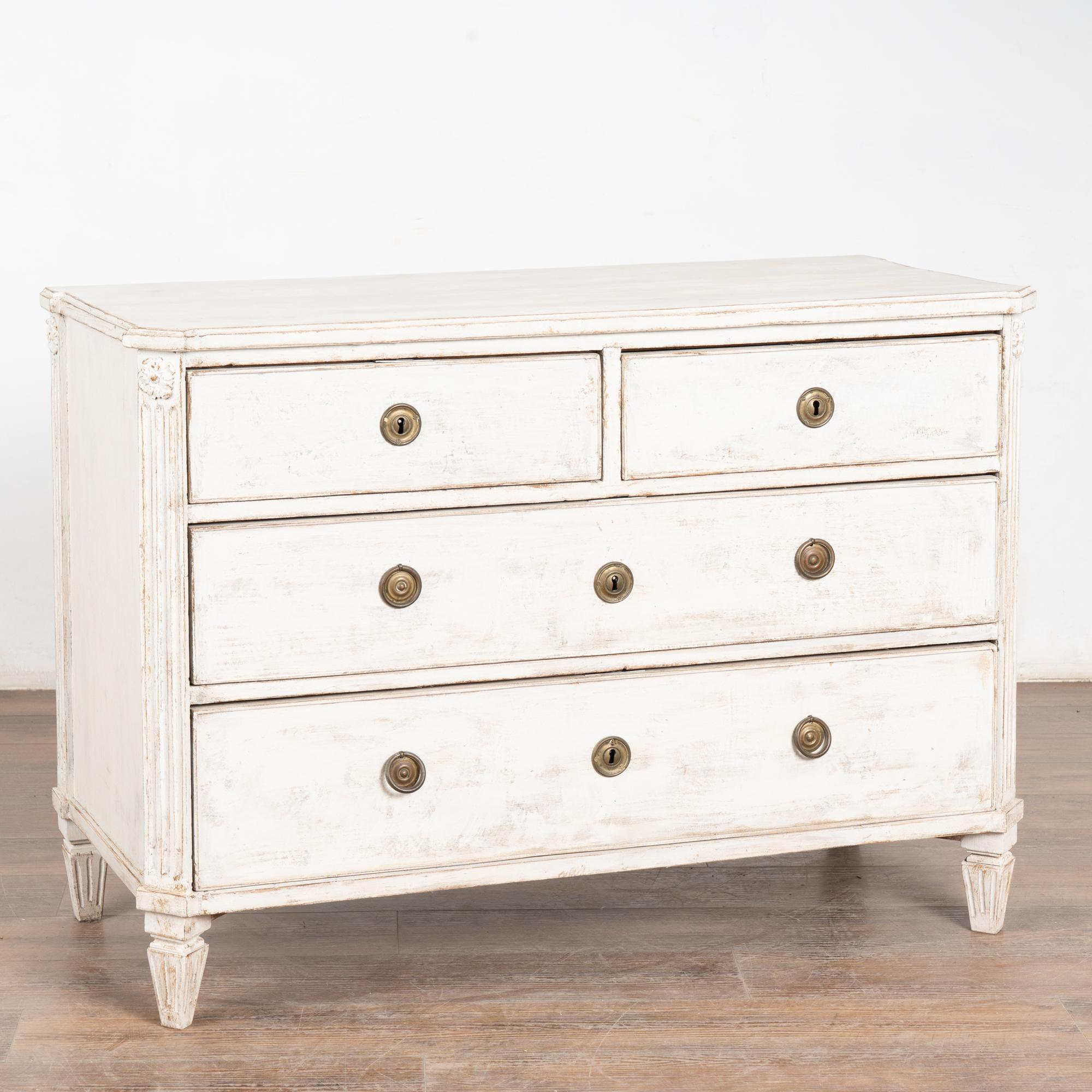Commode à quatre tiroirs en pin peint en blanc de style Gustavien ; deux plus petits sur deux plus longs.
La finition en peinture blanche appliquée par des professionnels est plus récente et légèrement vieillie pour s'adapter à l'âge et à la grâce
