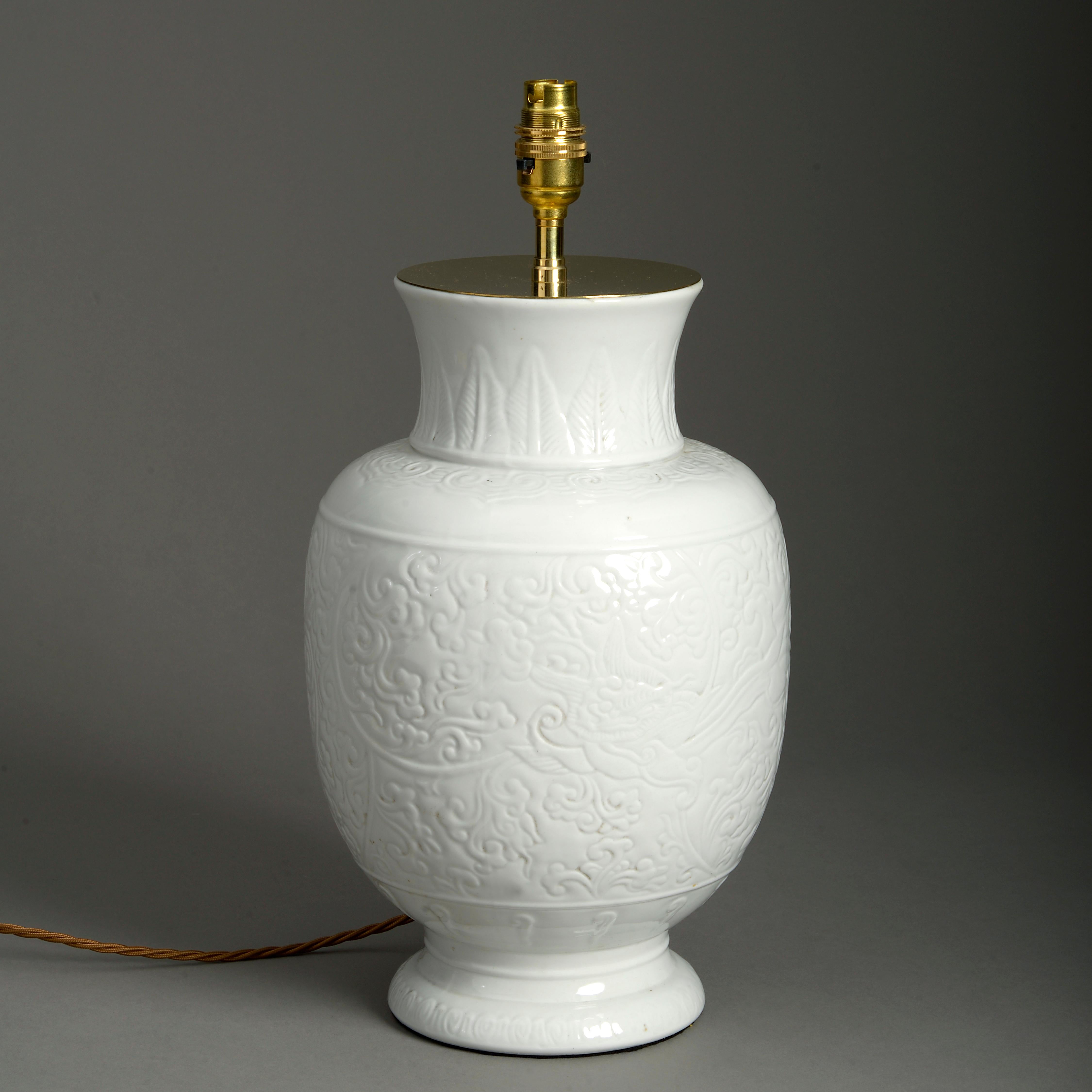 Vase en porcelaine blanche émaillée de la fin du 19e siècle, le corps avec une décoration incisée.

Aujourd'hui, elle est utilisée comme lampe de table.

Les dimensions se réfèrent uniquement au vase et n'incluent pas les composants