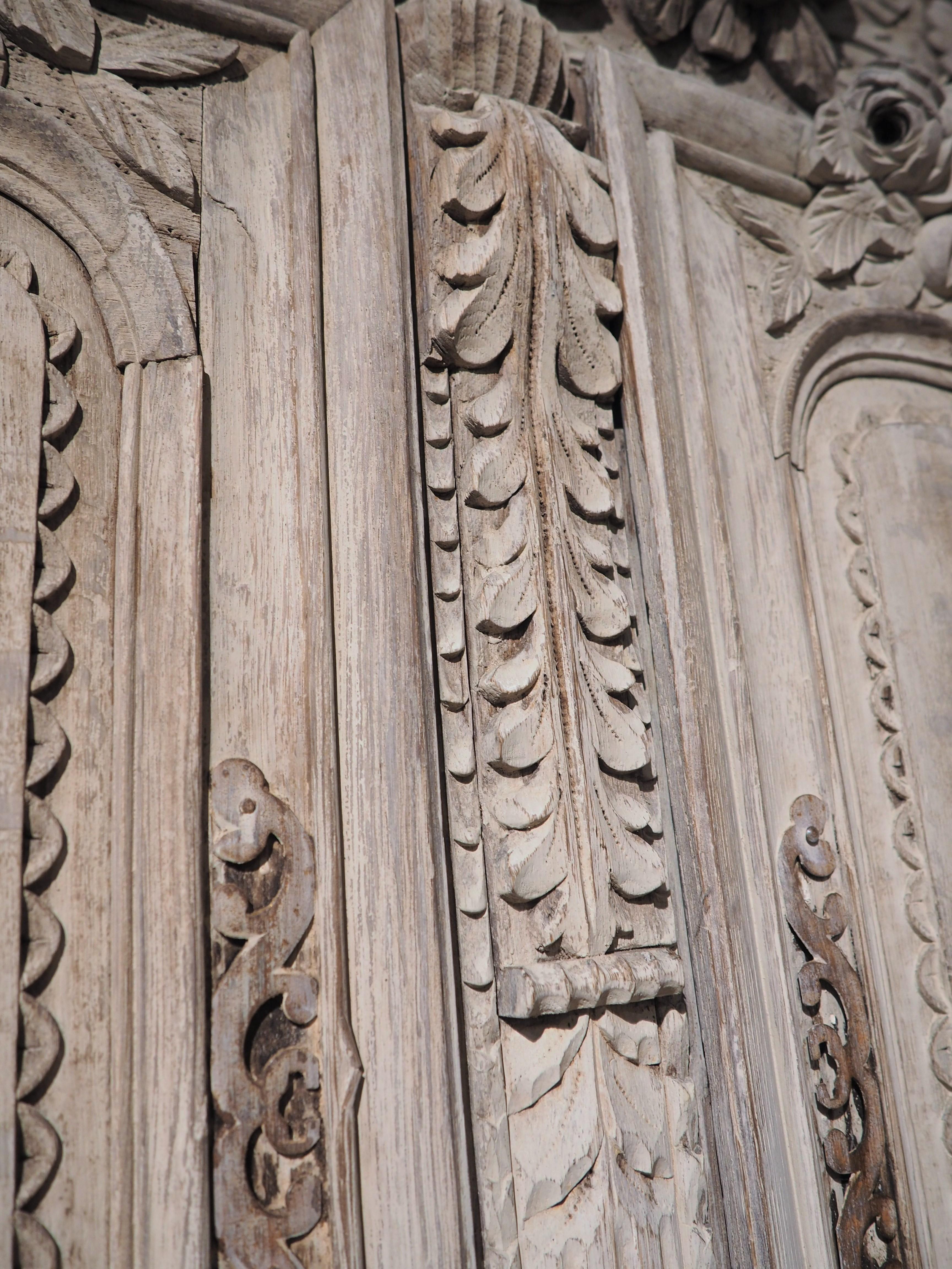 A truly beautiful piece of 19th century French furniture, this oak armoire was hand-carved in Normandy. The original finish was whitewashed at some point, giving the armoire an antique white color with undertones of cream and gray. A bluish-gray