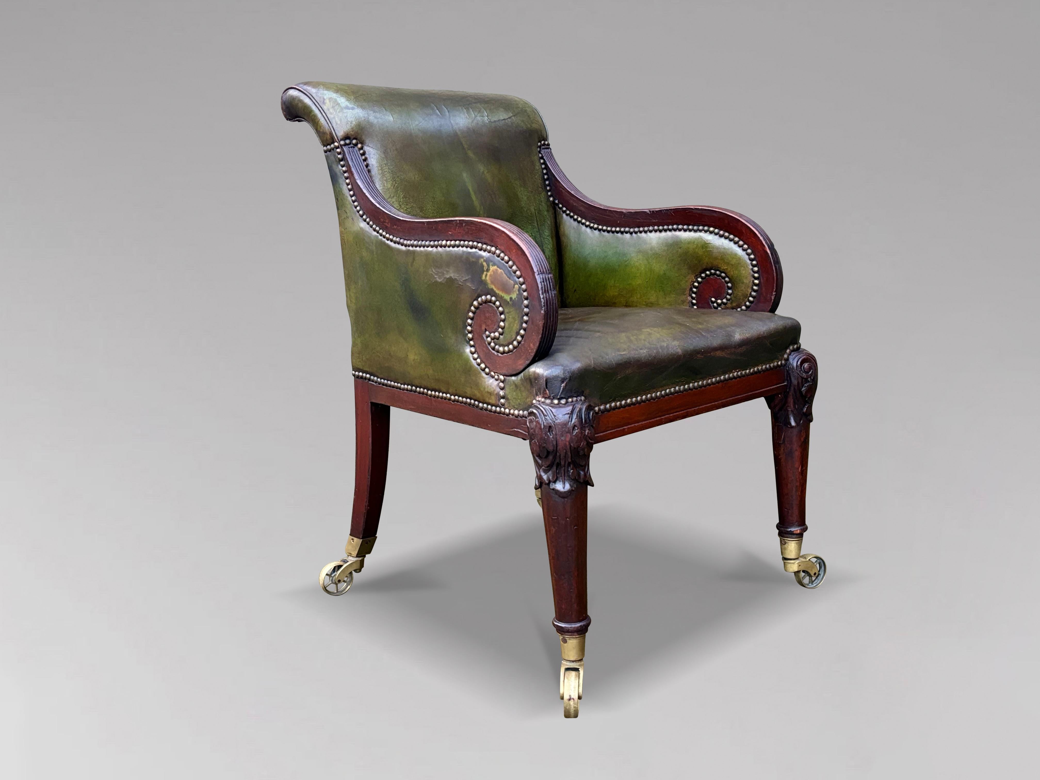 A stunning 19th century William IV period carved mahogany library armchair with a nicely shaped back and arms. Having lovely aged green leather upholstery and decorative brass studding, upholstered back, scrolled armrests with a sprung seat raised