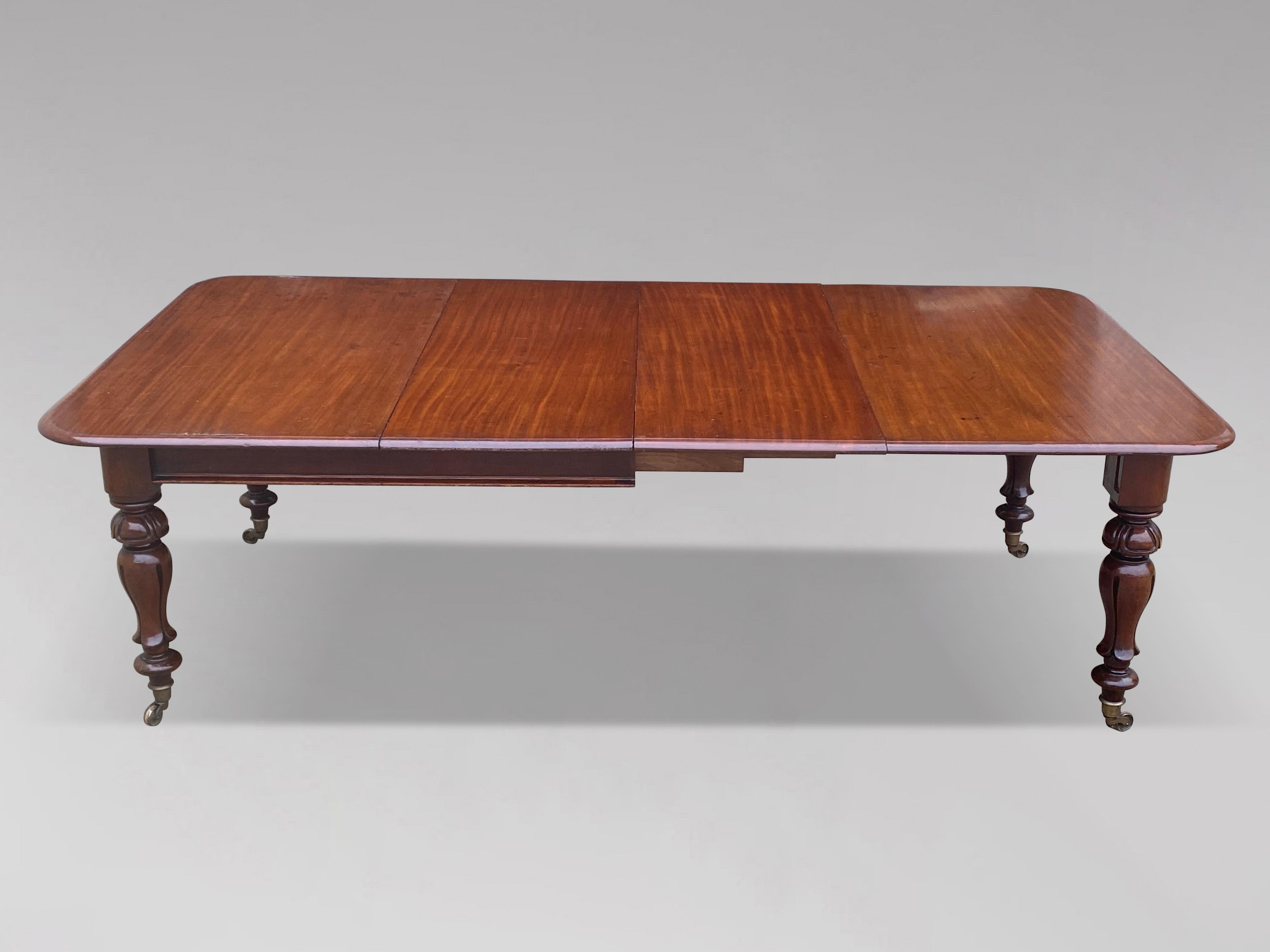 A great quality early 19th century, William IV period, mahogany pull-out extending dining table, the rounded rectangular moulded top over plain frieze raised on shaped turned legs ending on brass castors including two original leaves. Superb