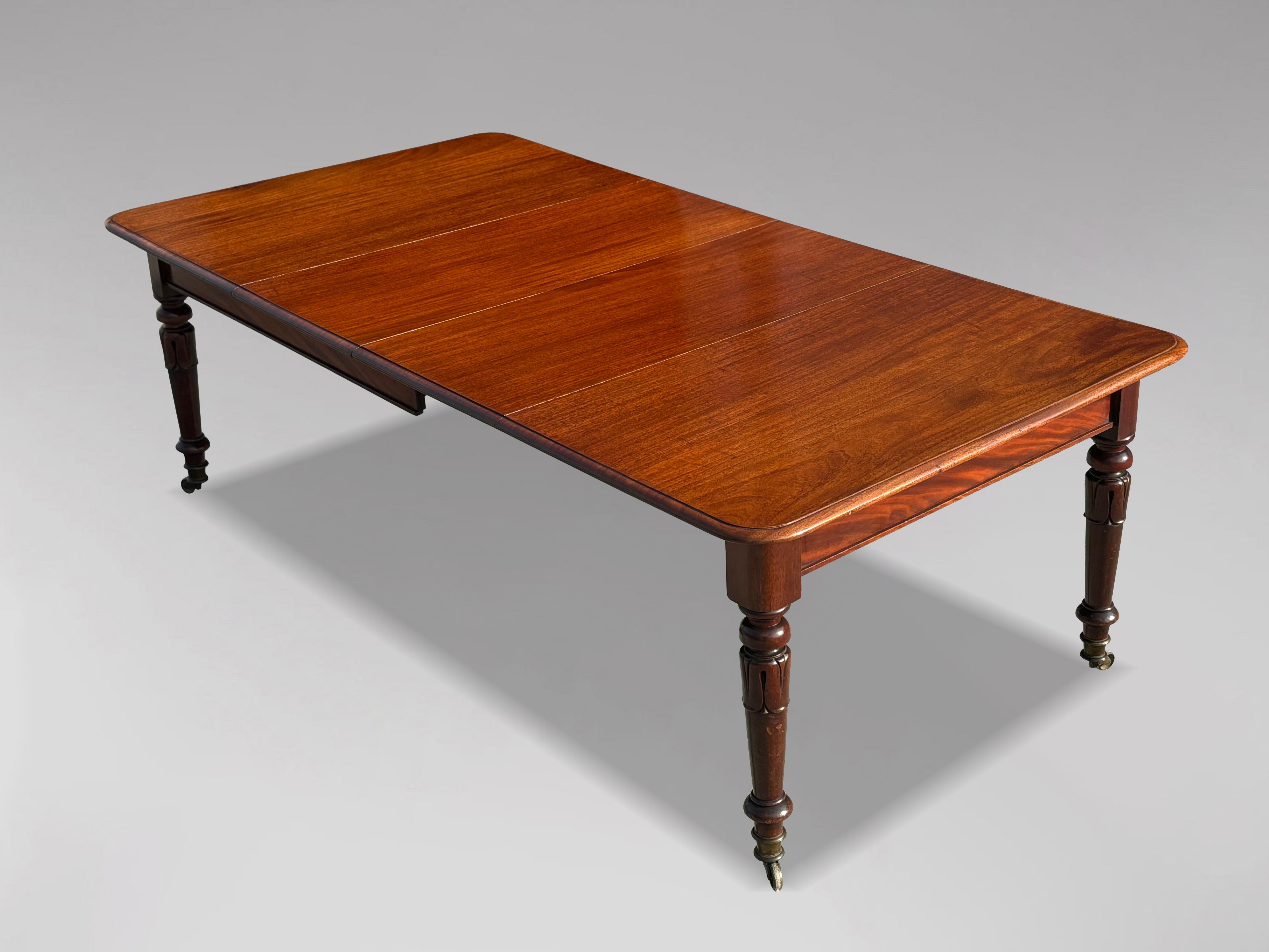 Esta mesa de comedor de caoba de principios del siglo XIX, de la época de Guillermo IV, es un magnífico ejemplo de fina artesanía y elegante diseño. Su rica pátina y su tapa de caoba bellamente labrada crean una pieza cautivadora, perfecta para