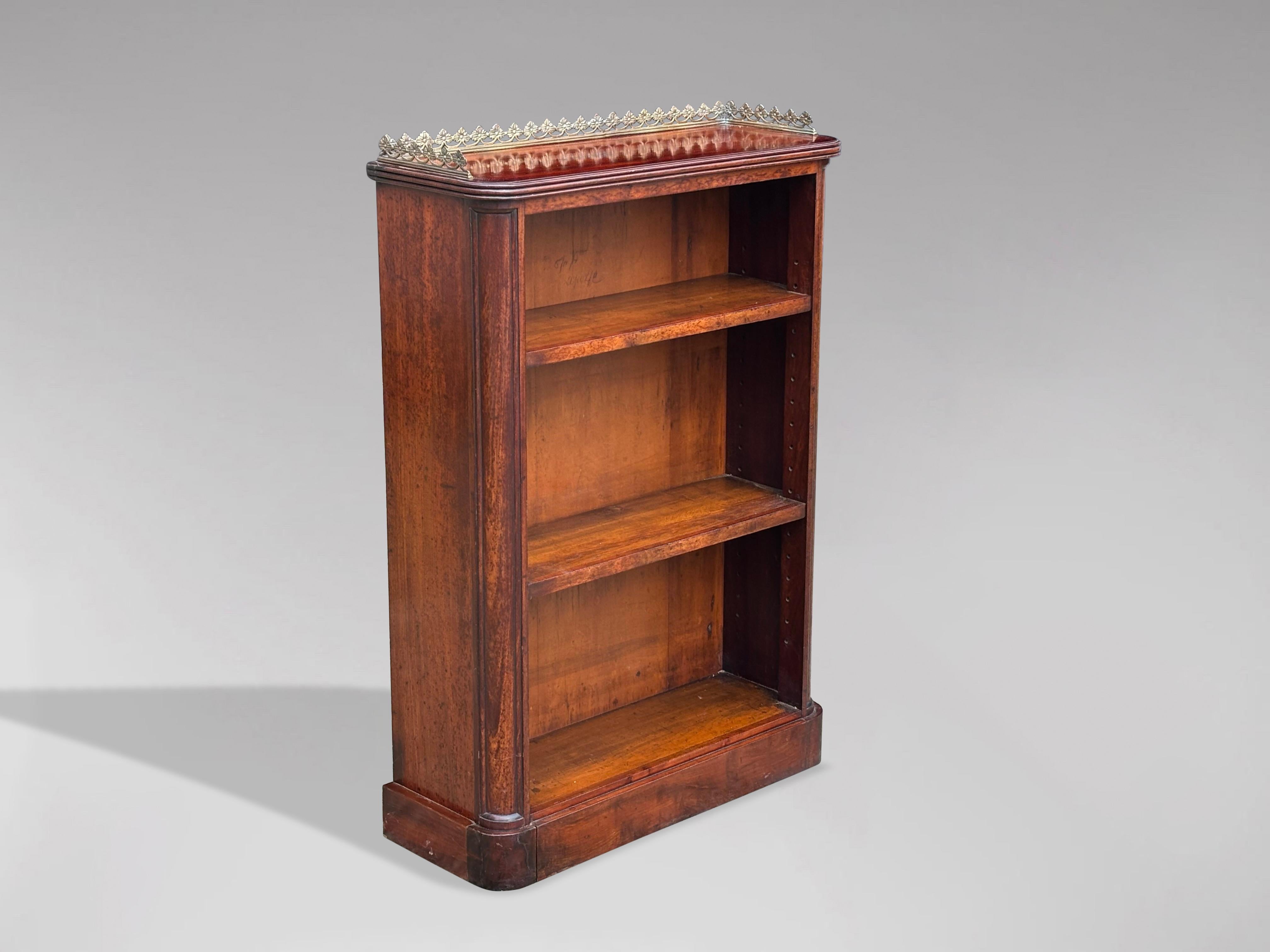 A small fine 19th century William IV period solid mahogany open low library bookcase. The rectangular well figured mahogany moulded rounded top surmounted by an ornate fretted brass gallery, above two adjustable shelves, flanked by rounded mahogany