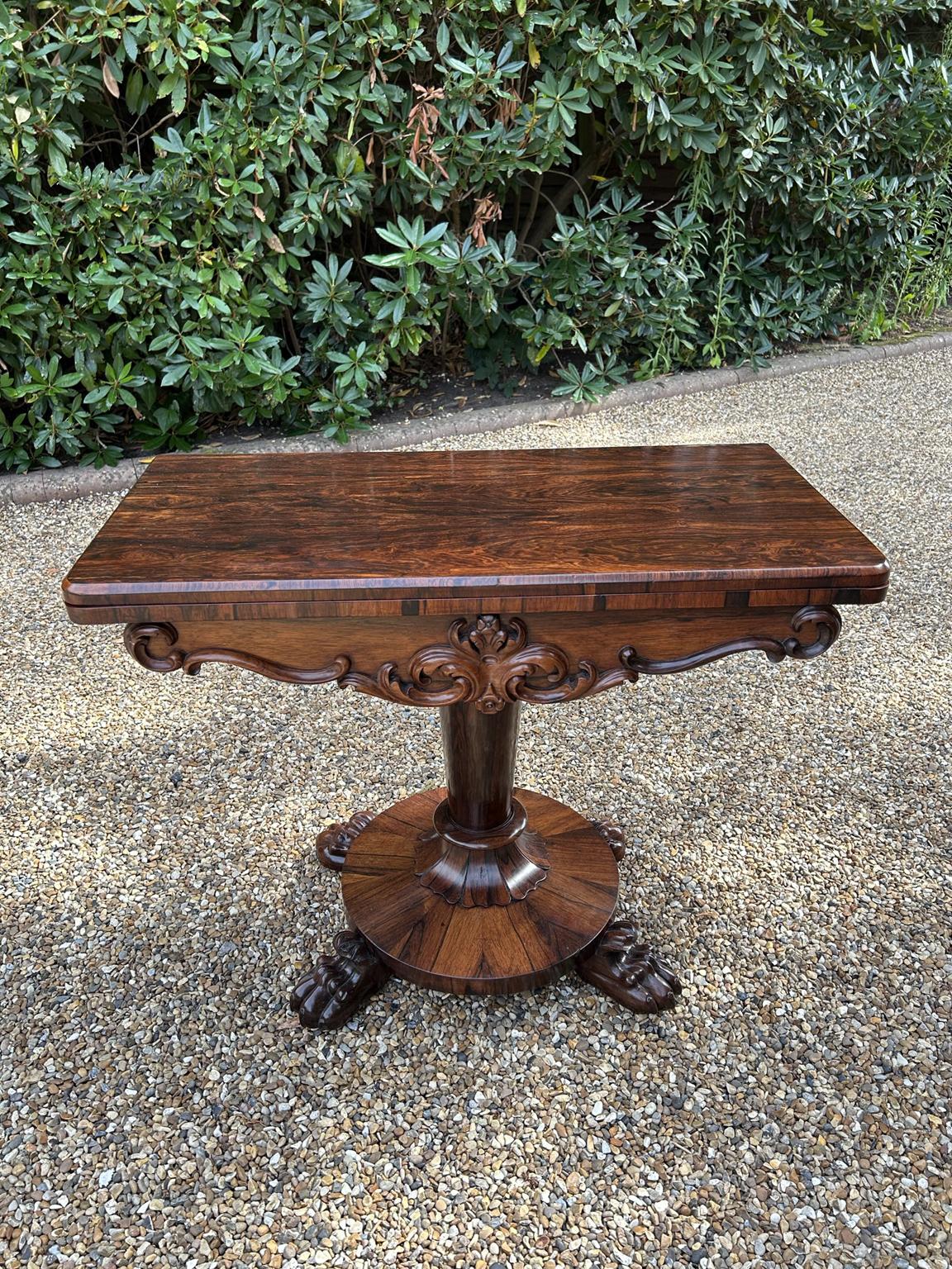 A very high quality 19th Century William IV – D Shaped Rosewood Card Table with beautifully figured rosewood throughout. The cylindrical turned rosewood column supported by circular base on carved rosewood lion claw feet on castors. The top rotates