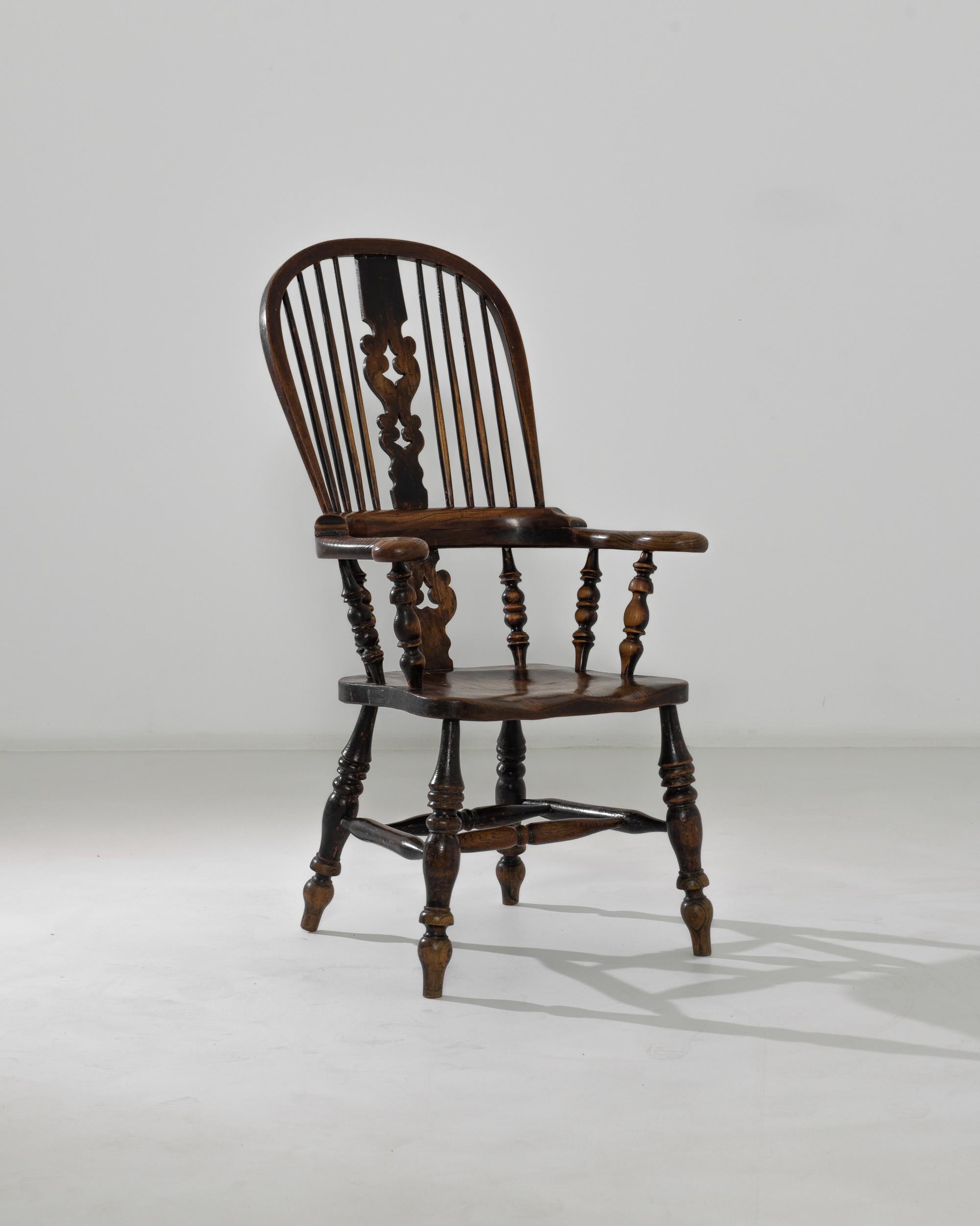 A hardwood ‘sack-back’ English Windsor armchair, circa 1850. Constructed with lathed arms and legs and spindles, this armchair leads the eye around its array of finely crafted details. Exhibiting the master’s attention to detail, indicative of the