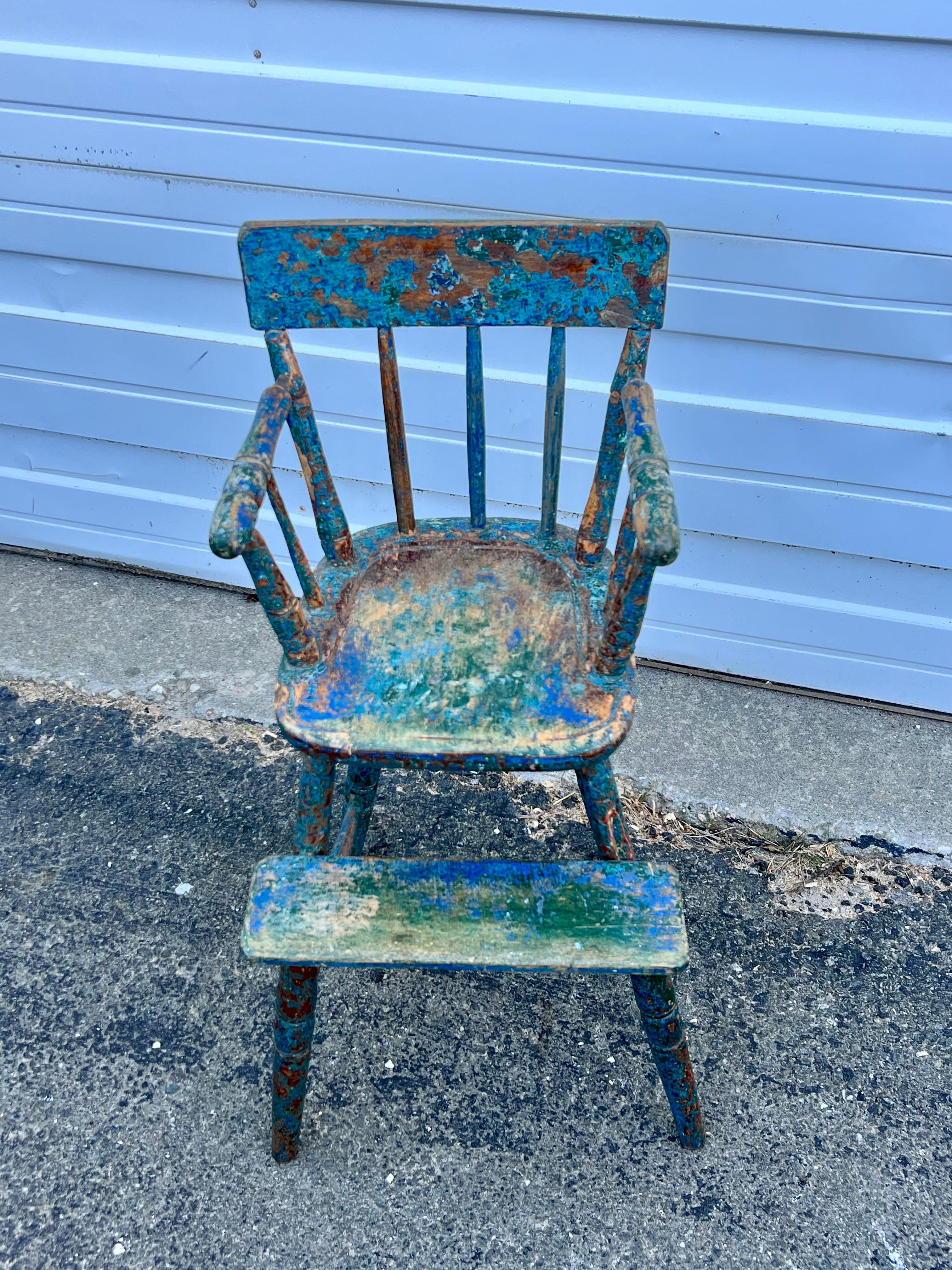 19th century Windsor style child's high chair.  Surface with various old paints in blues and greens.  Great as a plant stand.