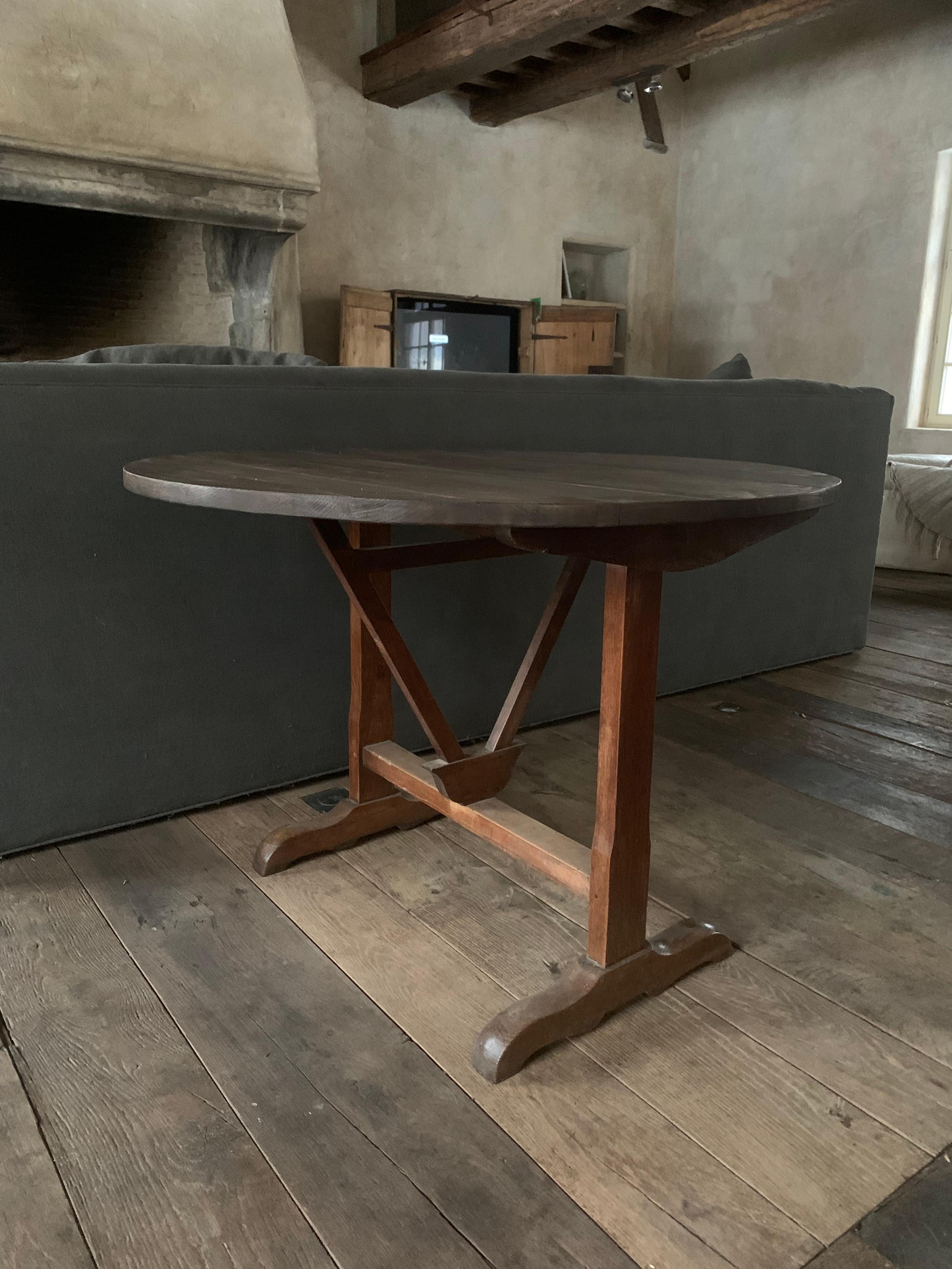 A good 19th century French Winetable. The oak top folds on the elm base.
These Vigneron tables were and are used on the French countryside as occasional tables in winecellars and on the field. Often made by farmers in the wintertime they are