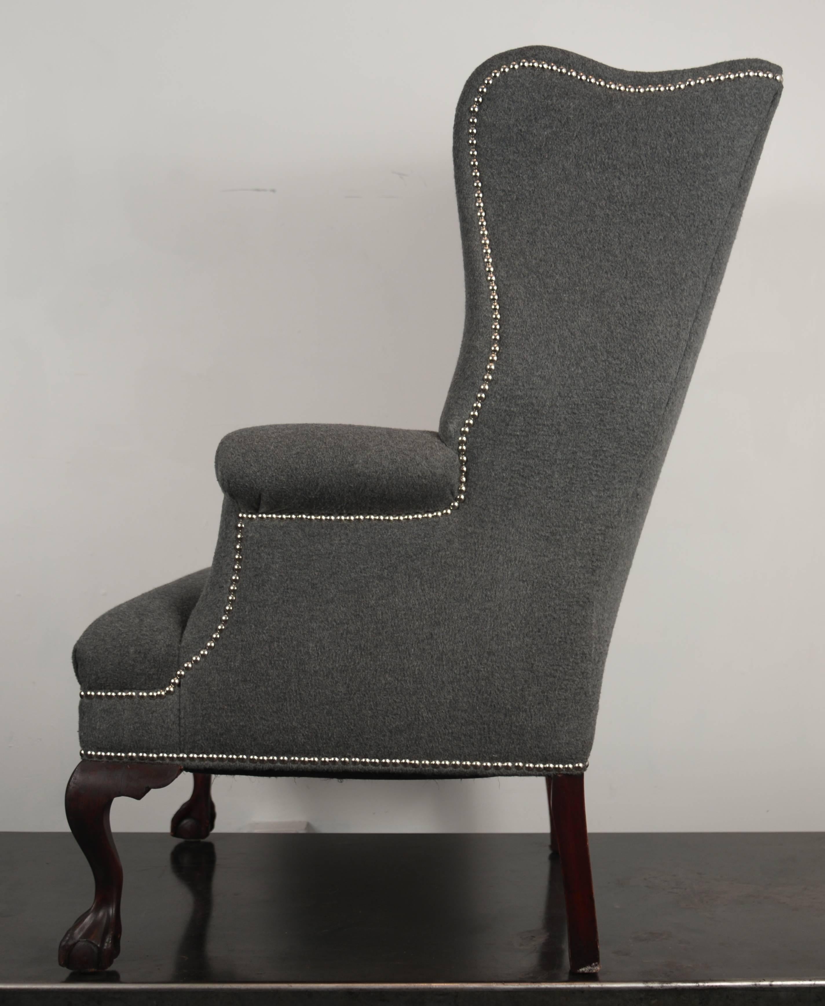 Fully restored 19th century stylized wingback chairs upholstered in gray wool and cashmere fabric and outlined in nickel nailhead trim.