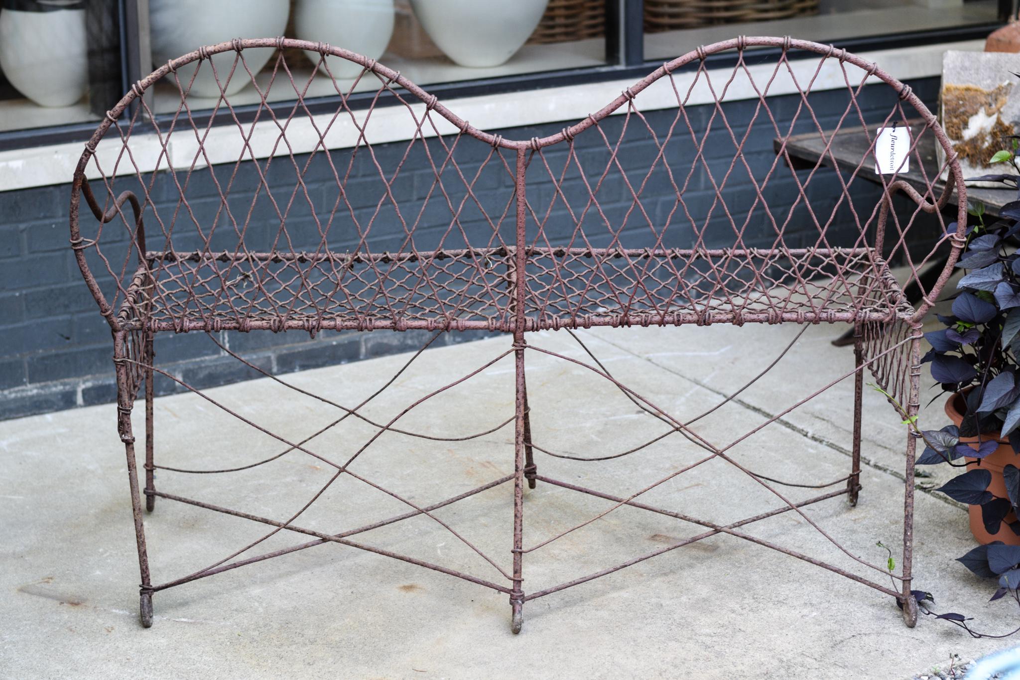 A fabulous vintage loveseat in excellent condition. Perfectly aged, this wire iron loveseat has brought all of the charm of the Victorian era to the 21st century garden. Structurally stable, this loveseat is a testament to the timeless craftsmanship