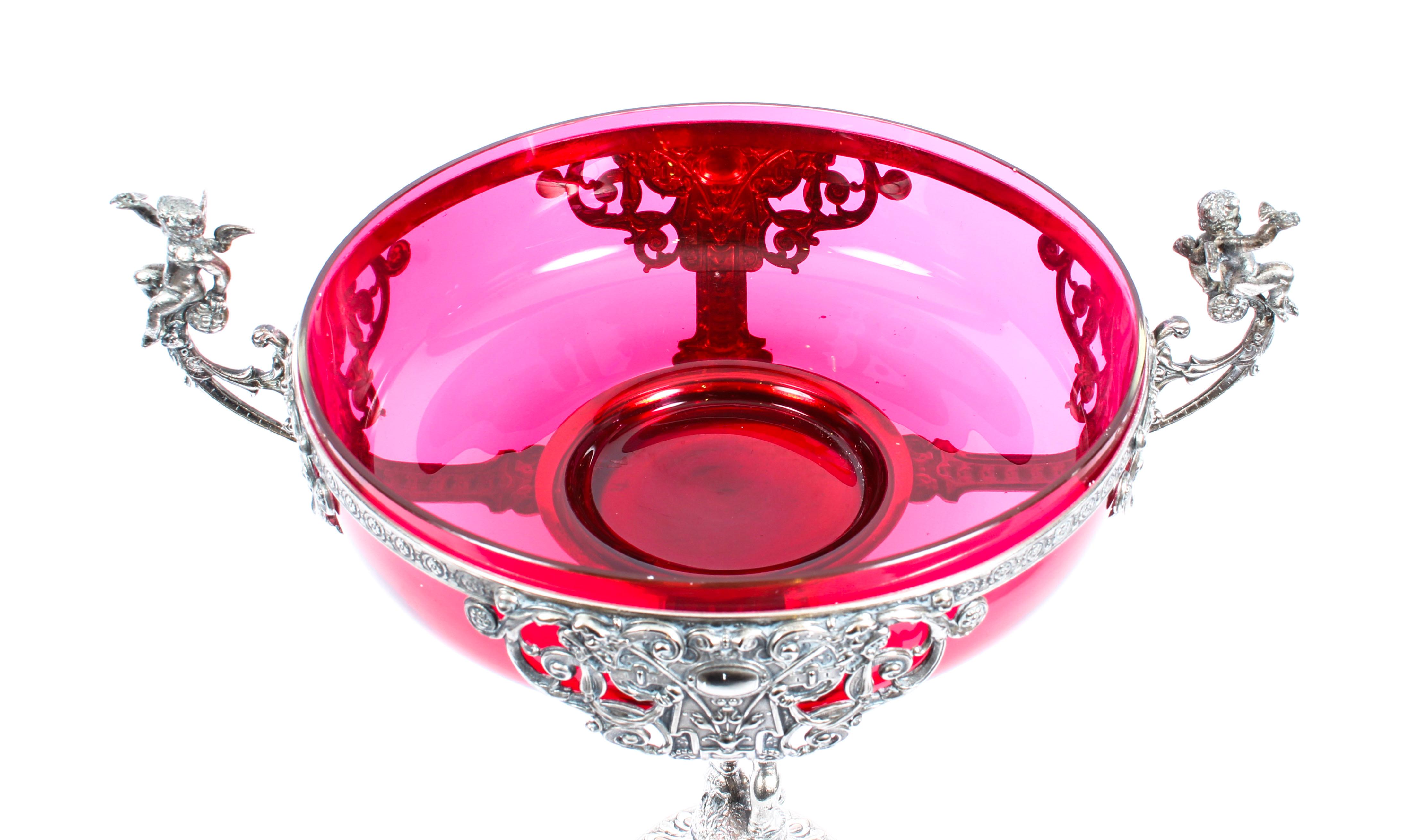 This is a magnificent German WMF Art Nouveau silver plated and cranberry glass centrepiece, circa 1890 in date.

This stunning centrepiece features two beautiful silver plated winged cherubs - one on each side of the large round cranberry glass