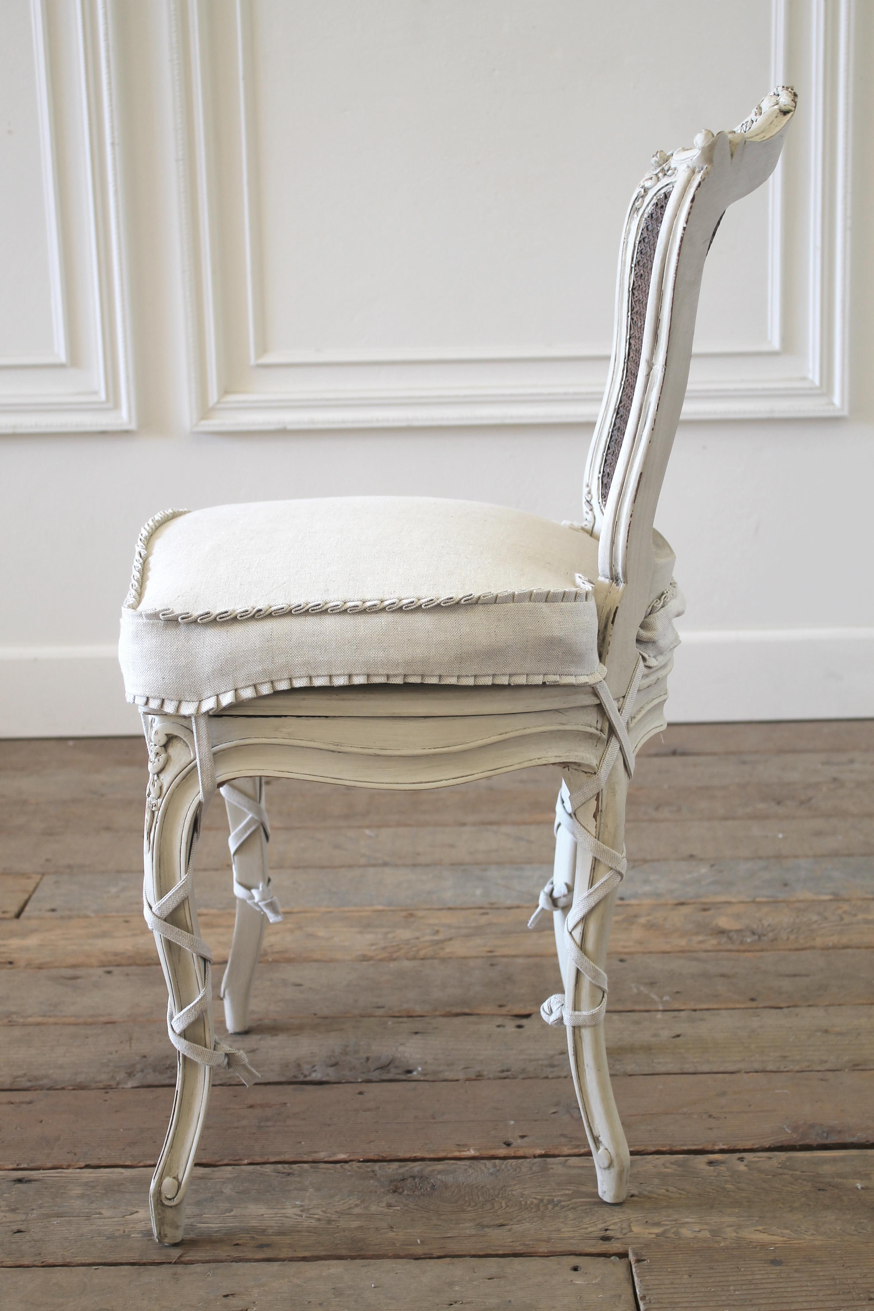 French country cane back vanity chair painted and upholstered Louis XV style vanity chair in natural linen. Painted in our soft oyster white, with subtle distressed edges, and finished with an antique glazed patina. This off white color blends