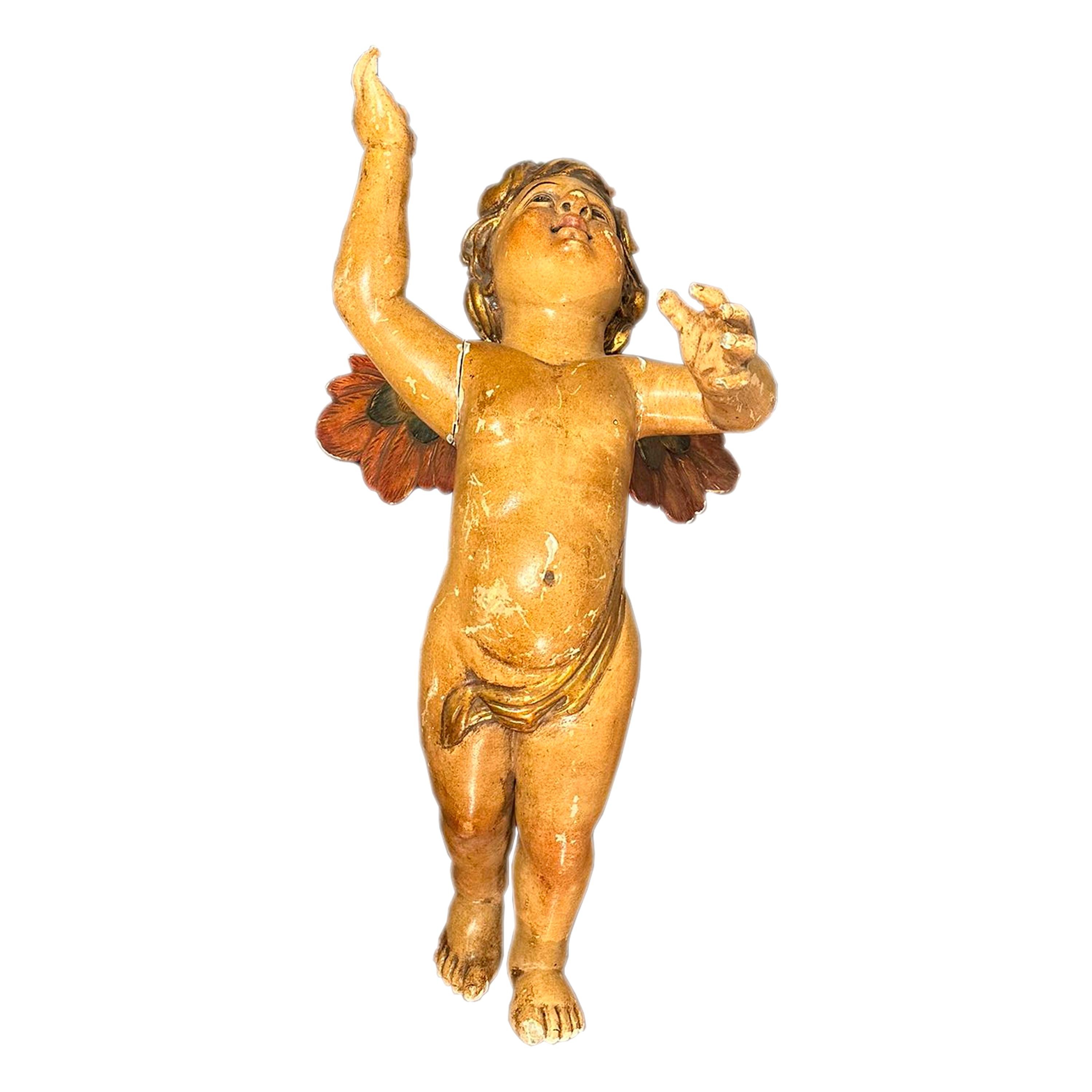 Spanish carving sculpture of an angel in flight. The piece is totally handcrafted in carved and polychromed wood with gold leaf details.
