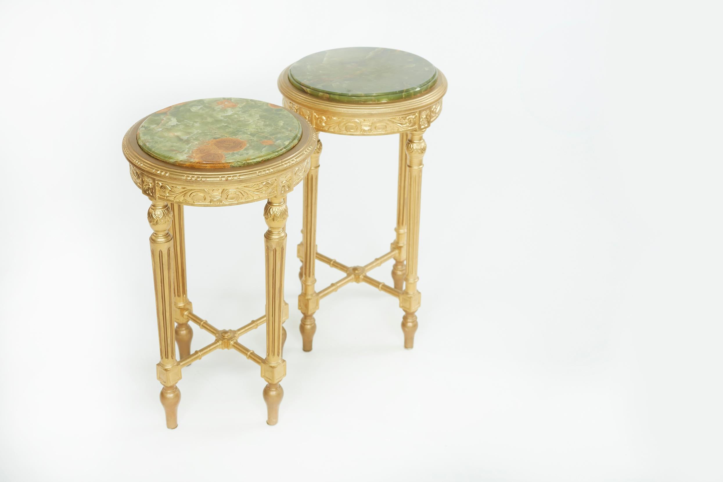 Hand carved gilt wood framed with exterior design details / Onyx top round shape pair side table. Each side table is in great condition. Minor wear consistent with age / use. Each table stands about 26 inches high x 15 1/2 inches top diameter.