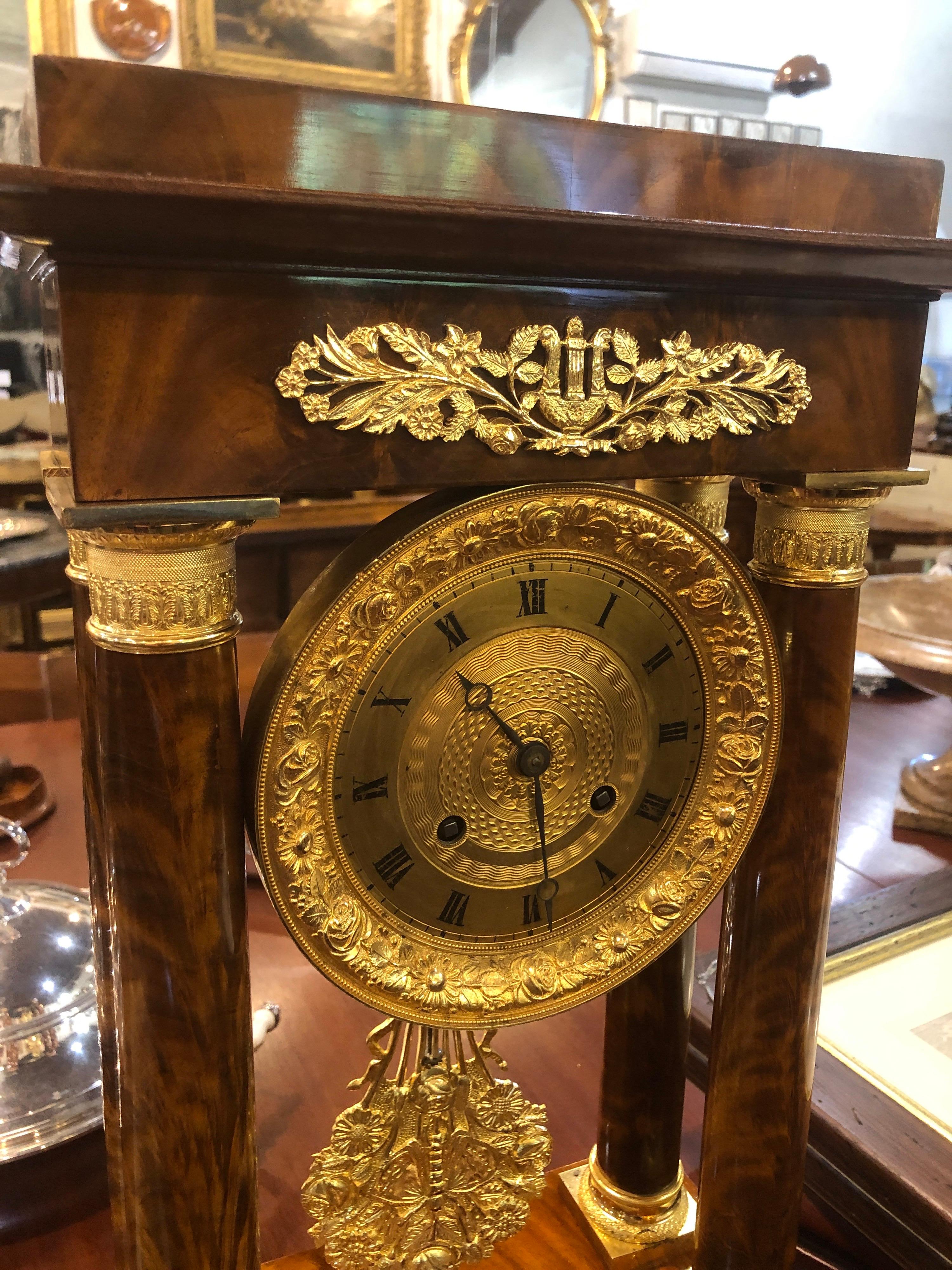 French portal clock with four columns, in flamed mahogany, the wooden part restored, only the mechanism needs to be restored. Fantastic bronzes still with original gilding, Fine chisel execution, beautiful work on the pendulum which represents a
