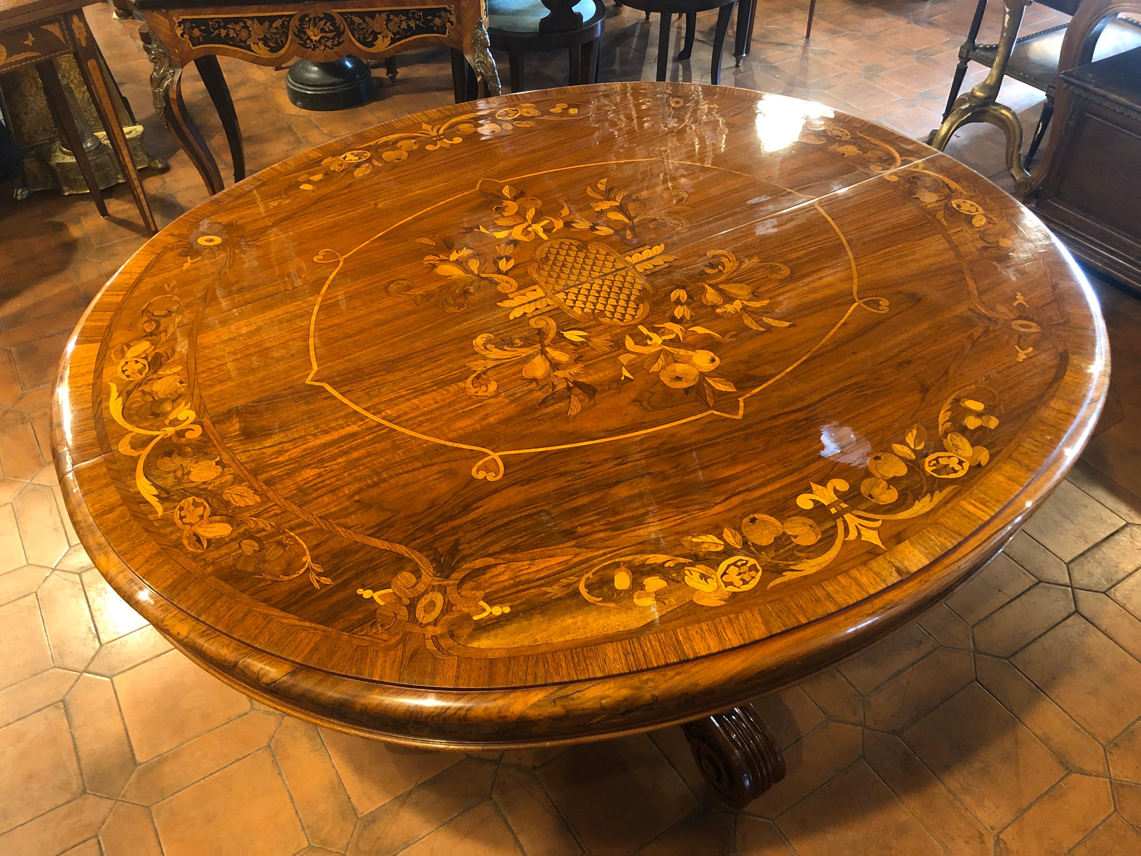 French extendable table, a work of art, completely inlaid on the top, on the edge and on the legs. Louis Philippe period, in walnut wood and inlaid in fruit woods with floral motifs. Table with soft lines and the inlay not being in contrast remains