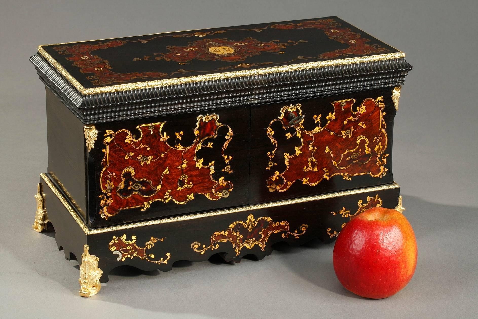 19th century tea caddy, the box is crafted of ebony and boasts intricate inlay of brass accented by mother of pearl. Inside, the wooden-lined interior includes two containers for tea crafted in clear wood, adorned with polychromatic wood marquetry,