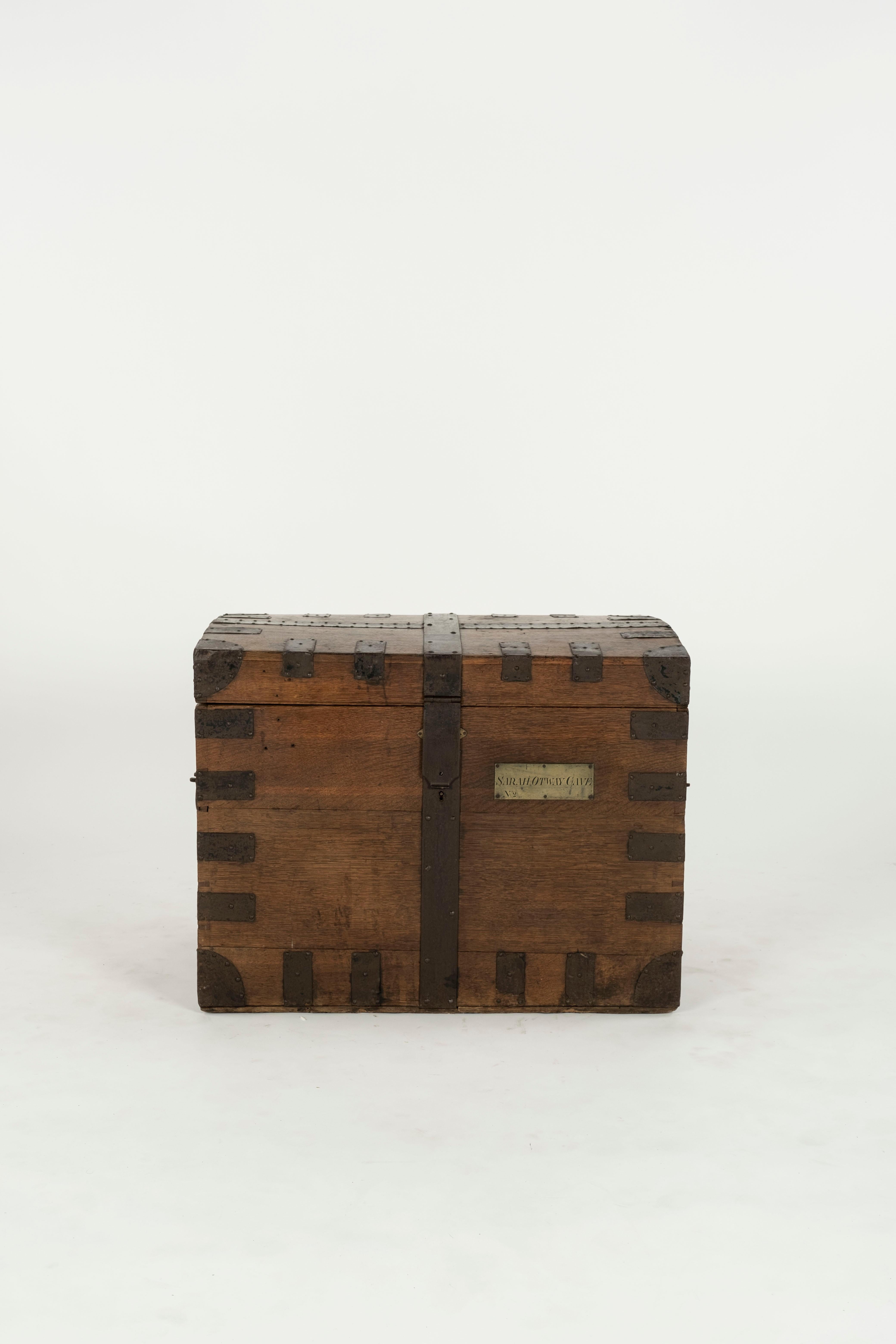 Malle en bois avec sangles et fermetures en fer.  Le coffre appartenait à Sarah Otway Cave comme indiqué sur la plaque.