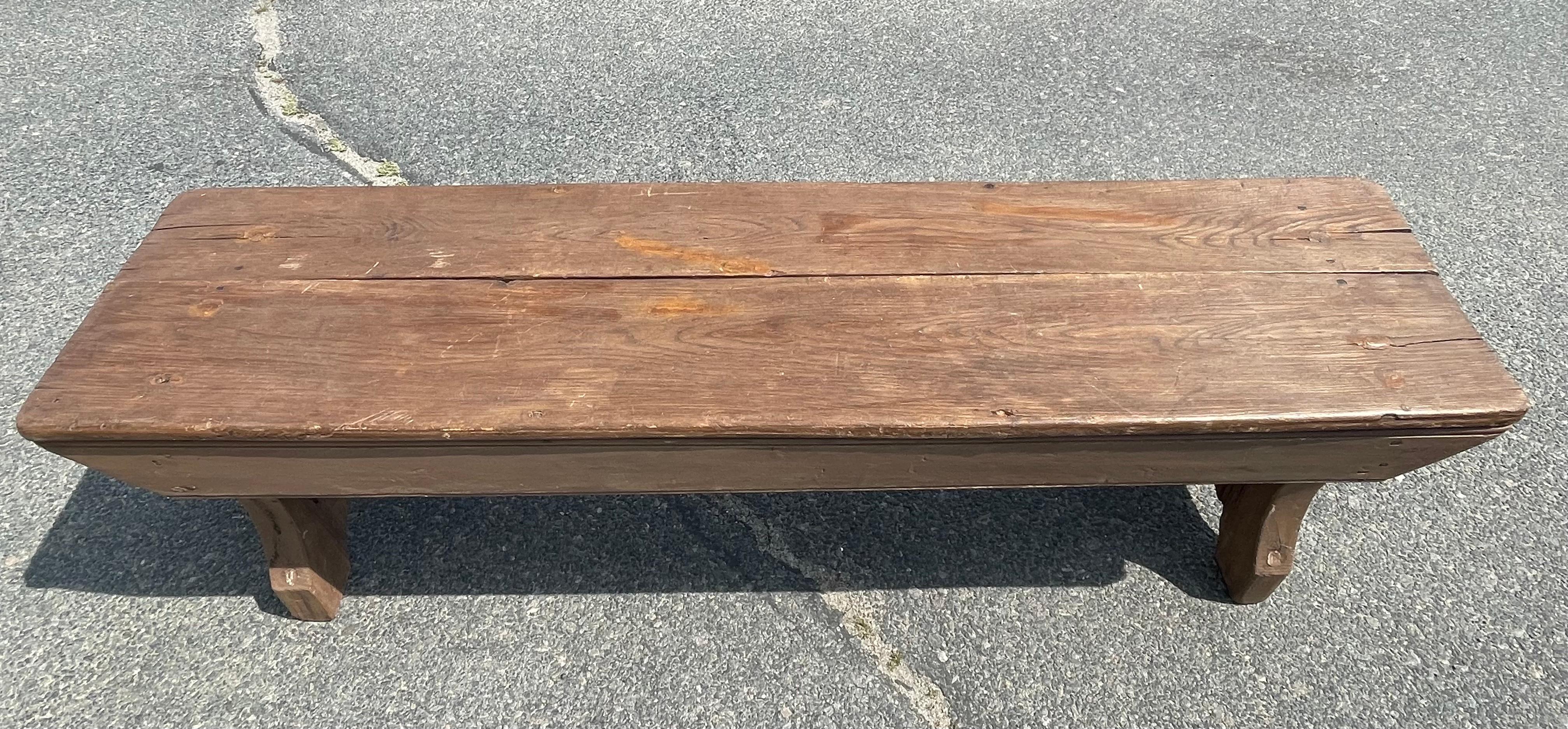 19th century Pine bench with old brown paint.  Boot jack ends.