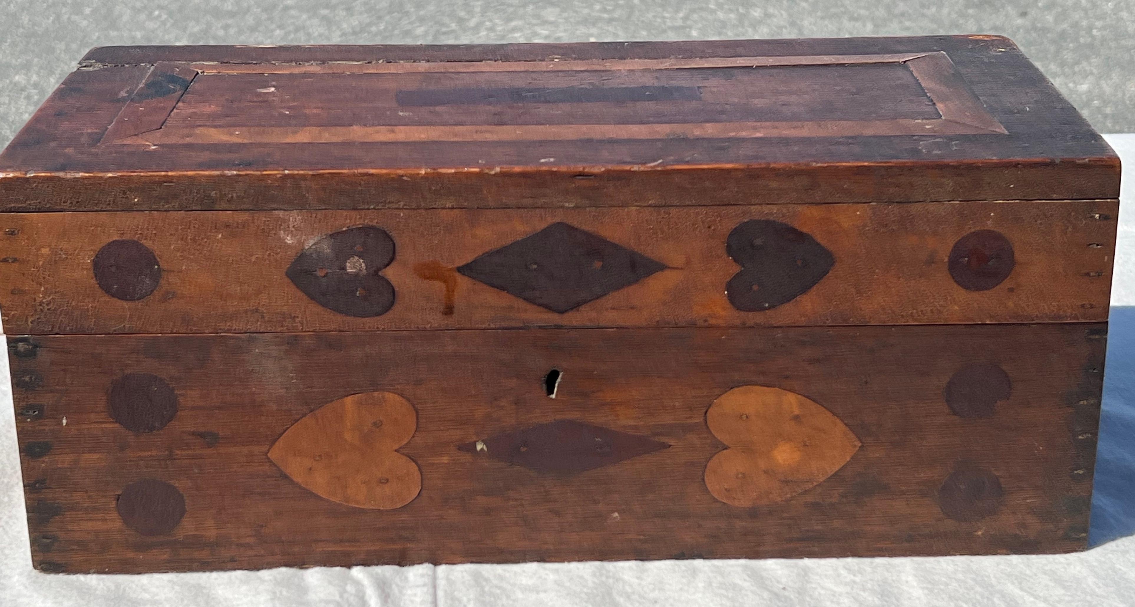 19th Century wooden box with hinged top.  Inlay in various woods throughout with patterns including hearts and diamonds.  Illegible graphite inscription on interior.