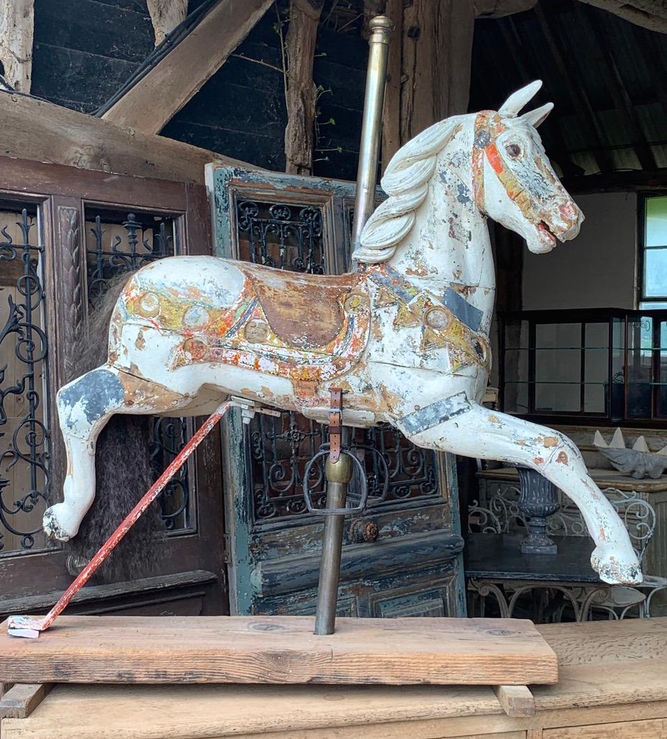 A beautiful and rare 19th century wooden carousel horse with original dry scrapped paint and glass eyes. Mounted on a later stand for display it now makes a wonderful decorative piece.