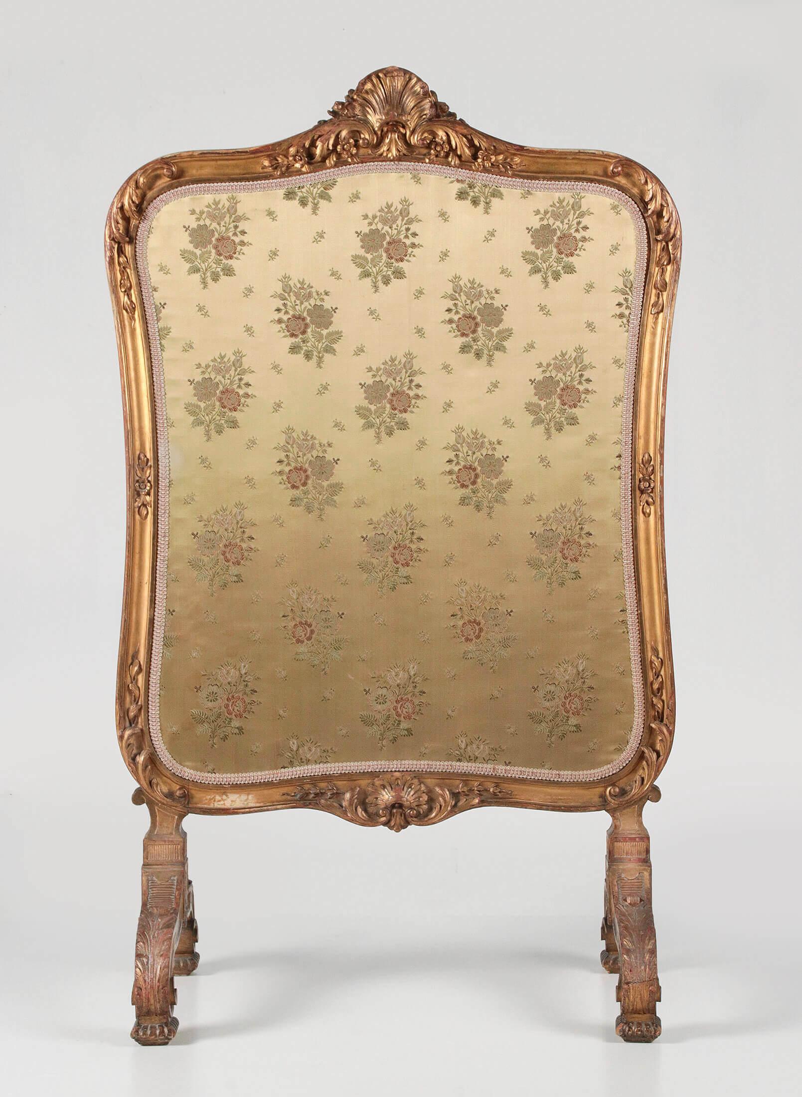 An antique gold leaf gilded wooden carved fire-screen. The style is French Régence revival. Made in France, 1870-1880. Both sides are upholstered with silk fabric. On the side the gilding have some wear.