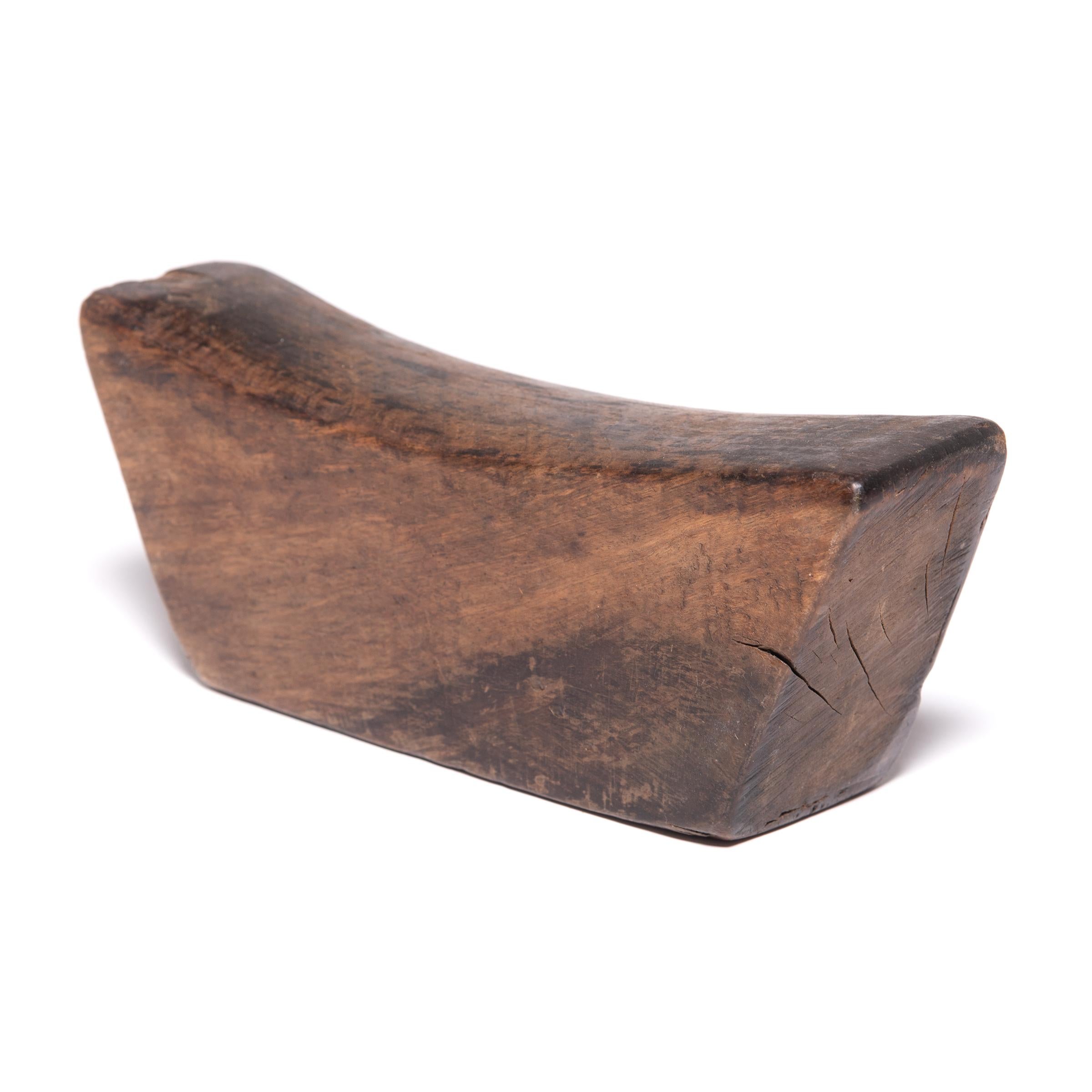 Made of Chinese northern elmwood, this smooth block of wood was once used by an upper-class woman as a headrest. The soft curve and height of the block not only supported her head and neck at rest, it also helped to preserve her intricate hairstyle.