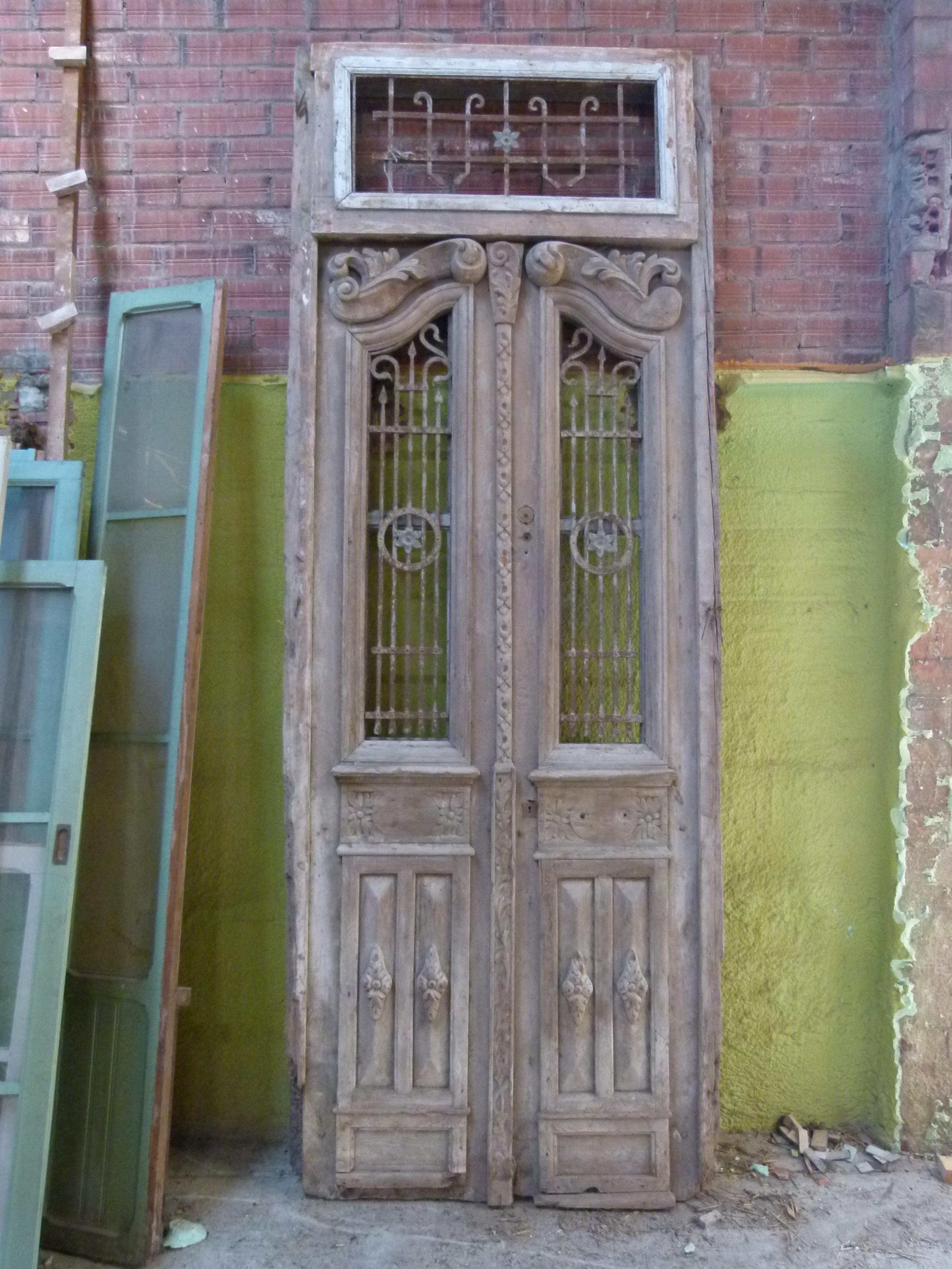 19th century wooden double front door with patina in art nouveau style.
 Carved wood and cast iron typical from this period.
The original patina of the door and its style will give the charm that your building or house needs.